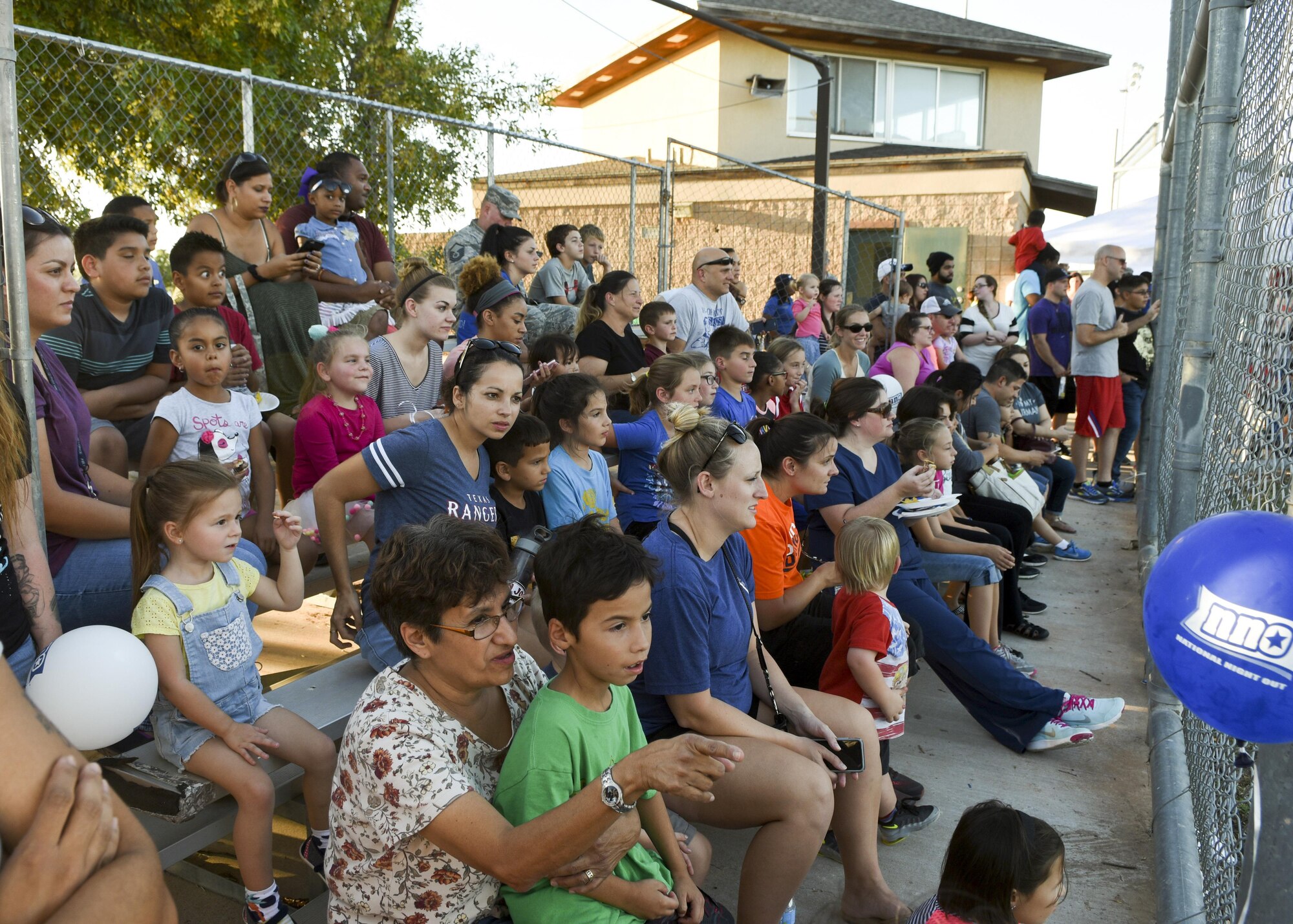 Team Dyess prepares to watch a K-9 demonstration by the 7th Security Forces Squadron military working dog handlers during National Night Out at Dyess Air Force Base, Texas, Oct. 4, 2016. Team Dyess gathered at the Dyess Youth Center to celebrate NNO, which is a campaign that promotes crime prevention, police-community partnerships and neighborhood camaraderie. Volunteers for the event provided food, games and prizes for Dyess families. (U.S. Air Force photo by Senior Airman Kedesha Pennant)
 
