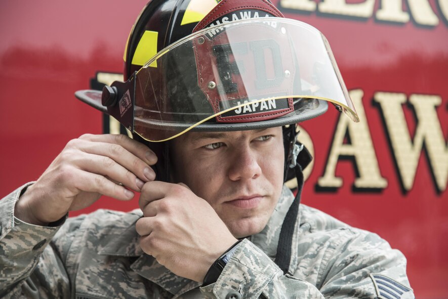 U.S. Air Force Staff Sgt. Cody Williams, the logistics NCO in charge with the 35th Civil Engineer Squadron, dons his fire helmet at Misawa Air Base, Japan, Sept. 27, 2016. Firefighters are given approximately one minute to fully suit up in their protective gear so they can quickly respond to calls. The equipment can protect firefighters in situations up to 500 degrees Fahrenheit for around five minutes. (U.S. Air Force photo by Airman 1st Class Sadie Colbert)