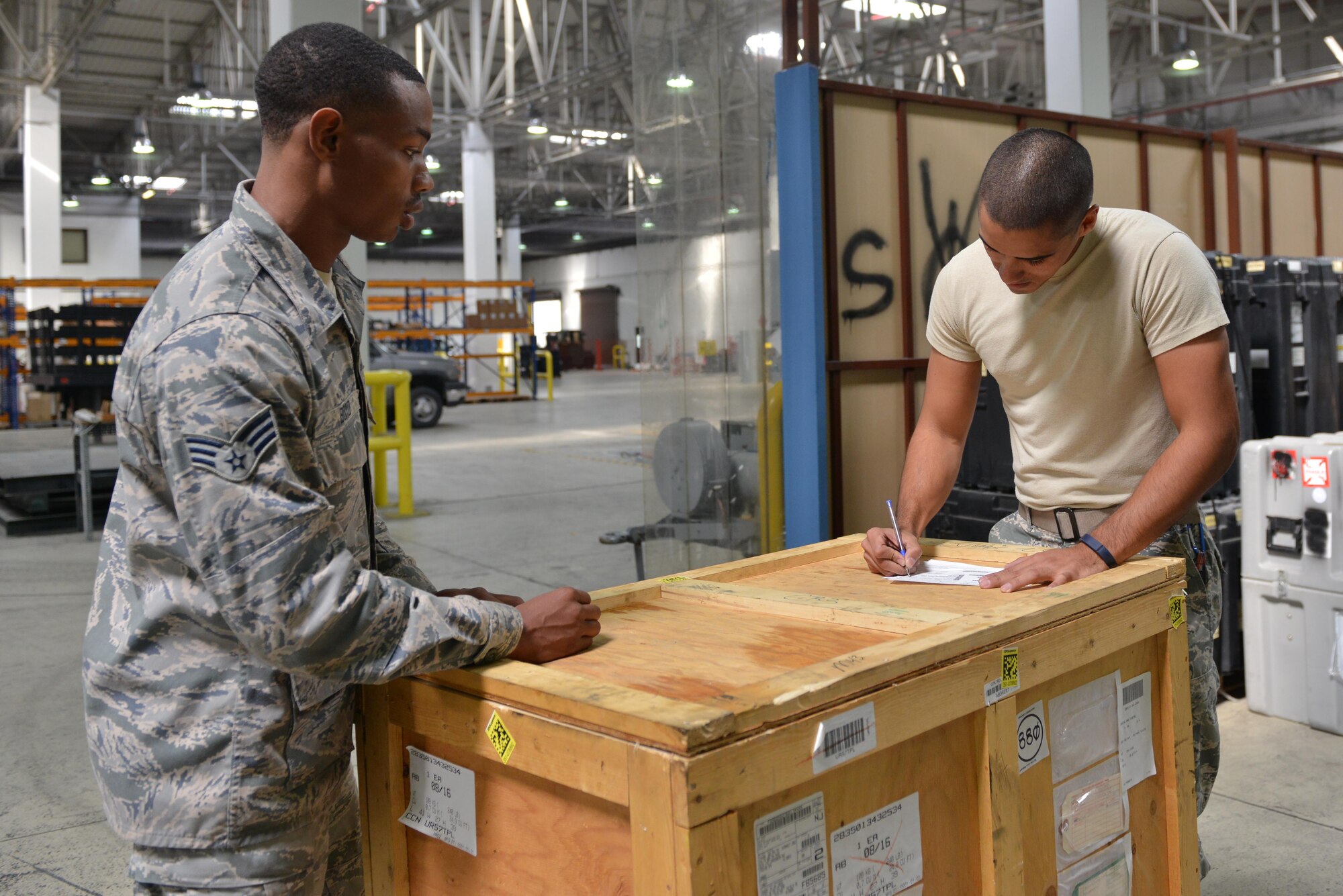 U.S. Air Force Senior Airman Turon Boyd (left), 39th Logistics Readiness Squadron service center journeyman, transfers property to an Airman in the supply warehouse Oct. 4, 2016, at Incirlik Air Base, Turkey. The supply warehouse harbors items such as aircraft parts and equipment necessary for aerial operations. (U.S. Air Force photo by Senior Airman John Nieves Camacho)