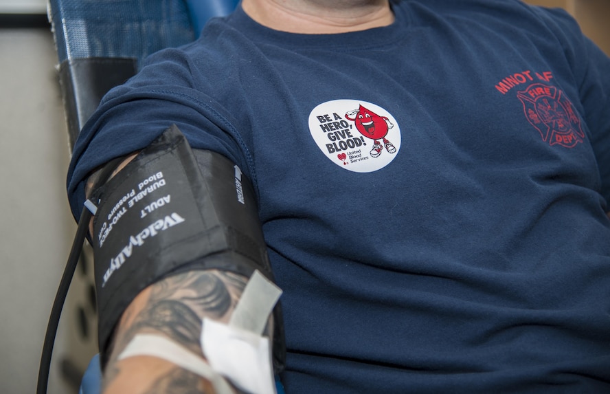 A 5th Civil Engineer Squadron firefighter donates blood during the Battle of the Badges blood drive at Minot Air Force Base, N.D., Sept. 30, 2016. During the blood drive, members earned points to determine who wins bragging rights and a trophy until next year’s drive. (U.S. Air Force photo/Airman 1st Class Christian Sullivan)