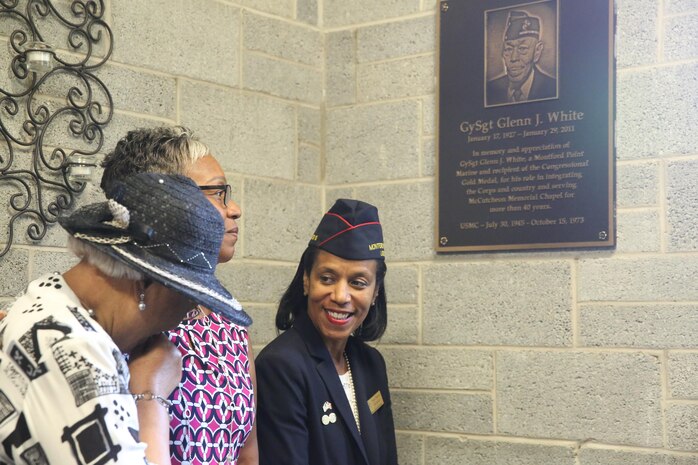 Gina Francis, daughter of Gunnery Sgt. Glen J. White, admires the plaque made in honor of her father with her sister and aunt at Marine Corps Air Station New River, Sept. 25. The congregation of McCutcheon Memorial Chapel honor Gunnery Sgt. Glen J. White with a plaque for his 27 years of active duty service to his country and over 40 to the chapel. (U.S. Marine Corps photo by Pfc. Juan Madrigal/Released)