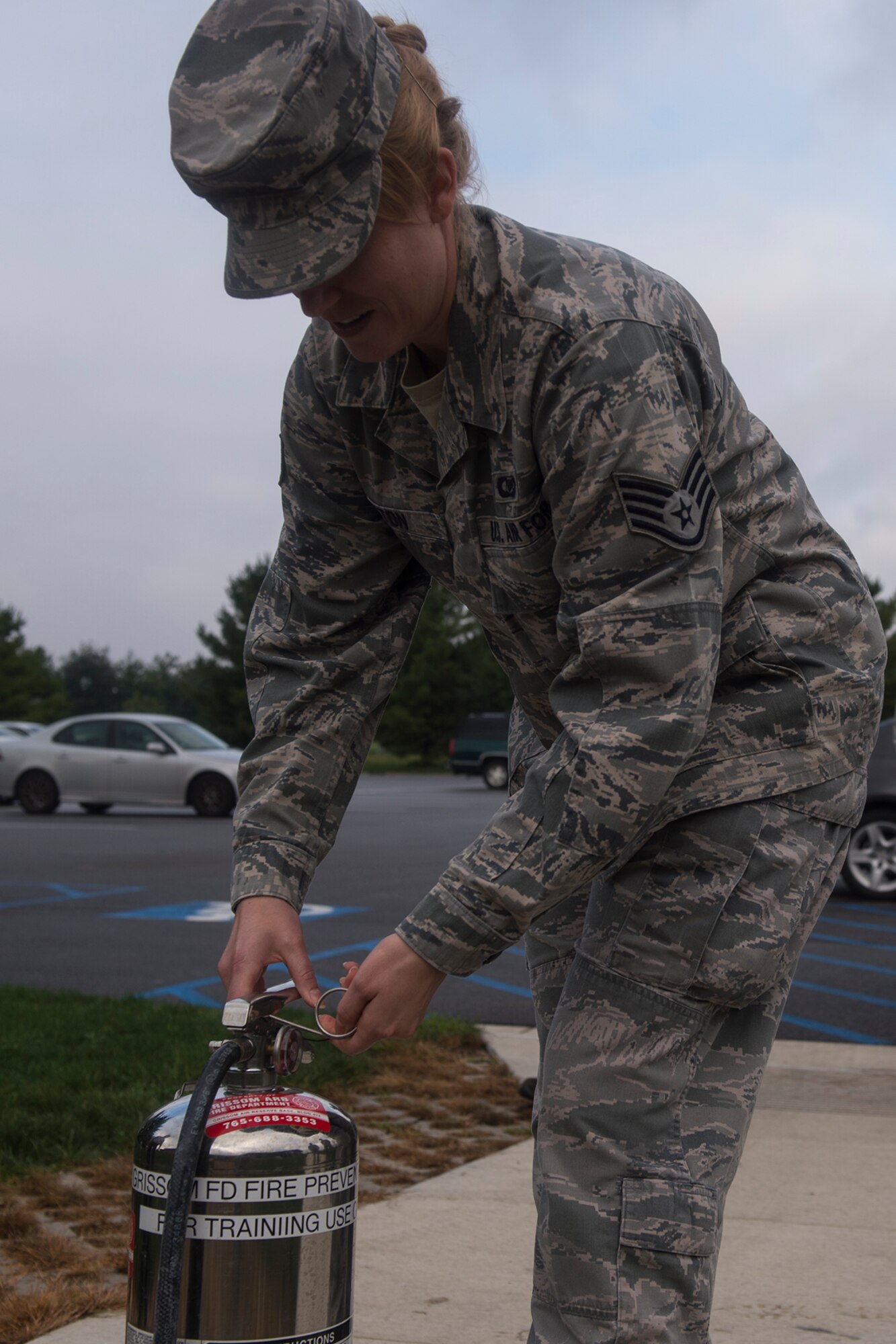 Staff Sgt. Lindsay Huston, 434th Air Refueling Wing emergency actions controller, pulls the pin on a fire extinguisher during a hands-on training October 2, 2016 at Grissom Air Reserve Base, Ind. Command post staff is trained to put out small fires instead of evacuating to ensure the command post is not left unmanned. (U.S. Air Force photo/Staff Sgt. Dakota Bergl) 