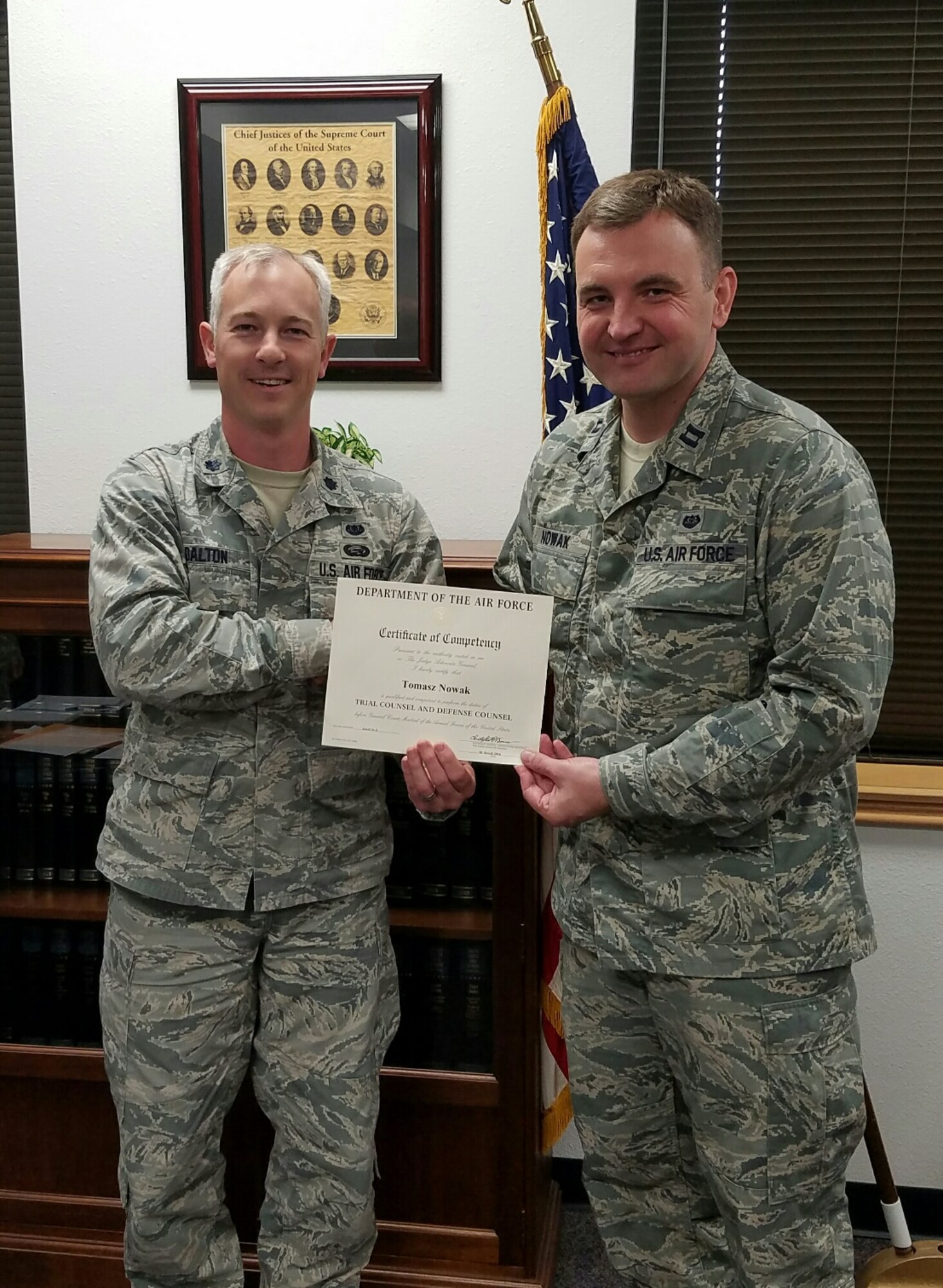 Lt. Col. Justin Dalton, 7th Bomb Wing staff judge advocate, presents Individual Mobilization Augmentee judge advocate Capt. Tomasz Nowak with his Air Force trial certification.