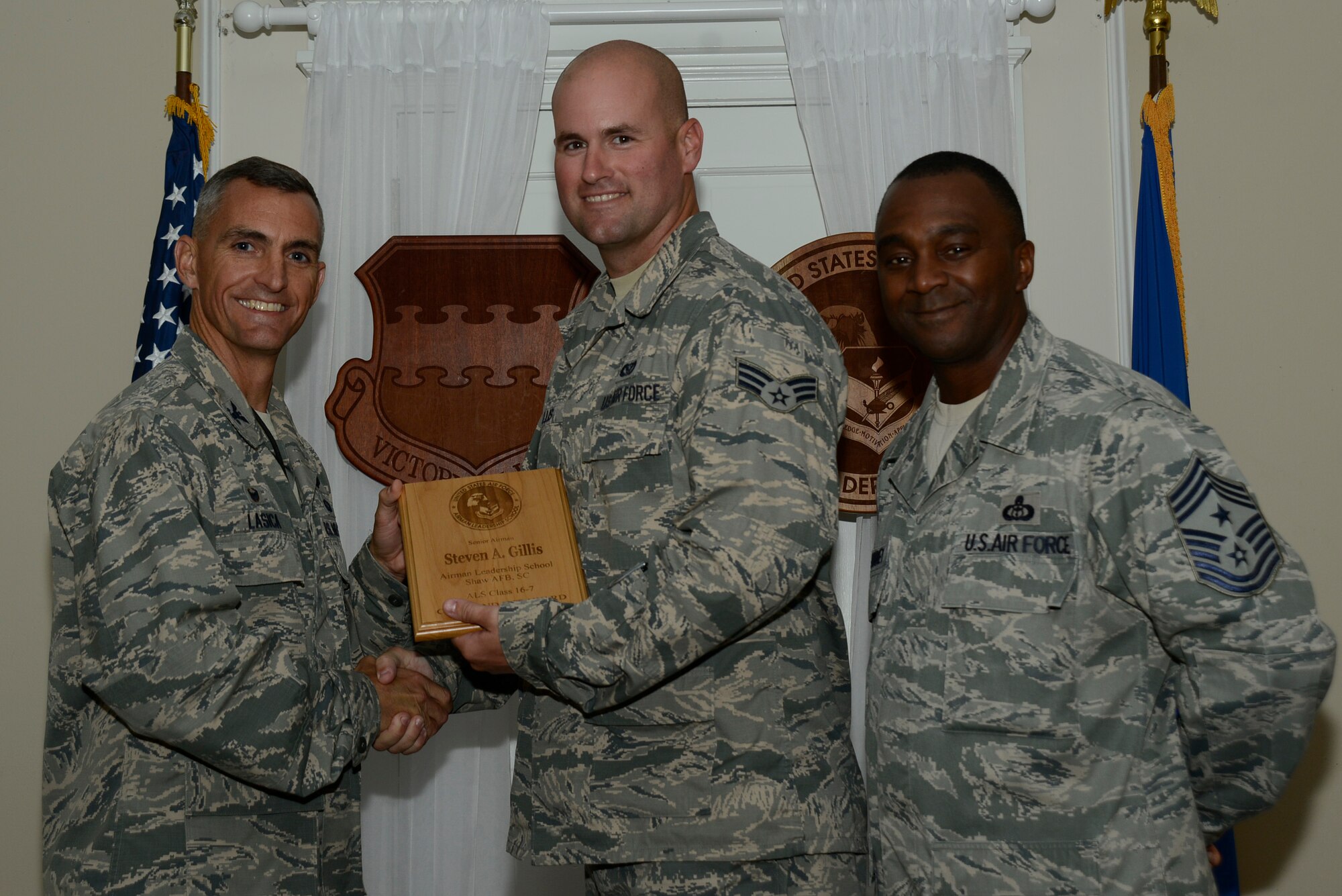 U.S. Air Force Senior Airman Steven Gillis, 20th Civil Engineer Squadron, receives the Senior Master Sgt. David B. Reid Airman Leadership School Commandant’s Award from Col. Daniel Lasica, 20th Fighter Wing commander, during the ALS Class 16-7 graduation at Shaw Air Force Base, S.C., Oct. 5, 2016. The Commandant’s Award is given to the student who most exemplifies professional military qualities as chosen by their peers, the primary instructors, and the ALS commandant. (U.S. Air Force photo by Airman 1st Class BrieAnna Stillman)