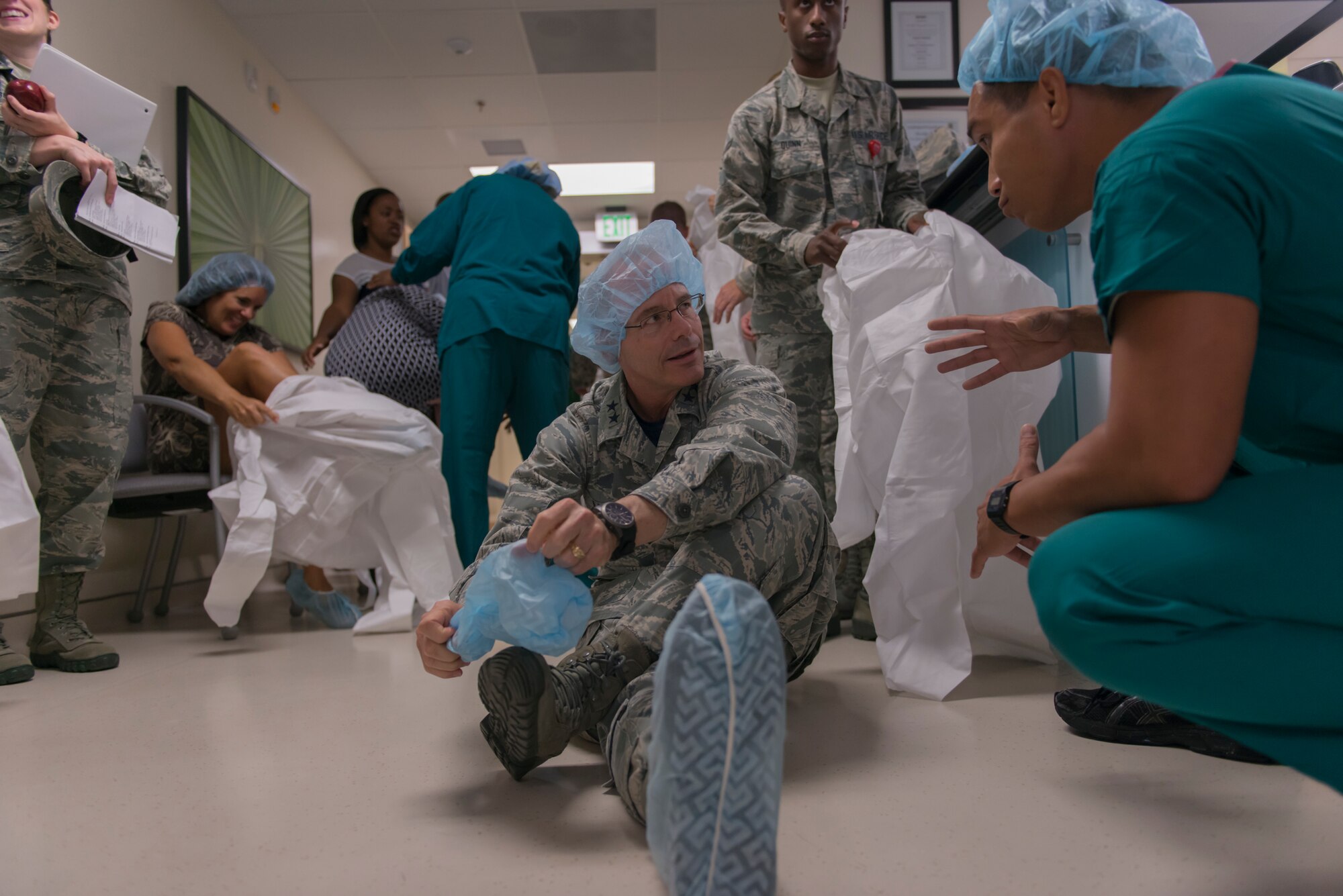 Maj. Gen. Robert LaBrutta, 2nd Air Force commander, slips on medical scrubs in before entering the Hybrid Operating Room at the Keesler Medical Center during an immersion tour Sept. 22, 2016, on Keesler Air Force Base, Miss. The tour allowed LaBrutta to become familiar with the 81st Training Wing mission, operations and personnel. (U.S. Air Force photo by Andre Askew/Released)