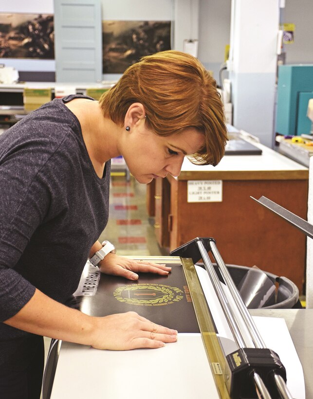 Penny Latimer, electronic duplicating system technician at Fort Riley, cuts a straight edge on a poster Sept. 22 at Defense Logistics Agency Document Services, 263 Cameron Ave.
