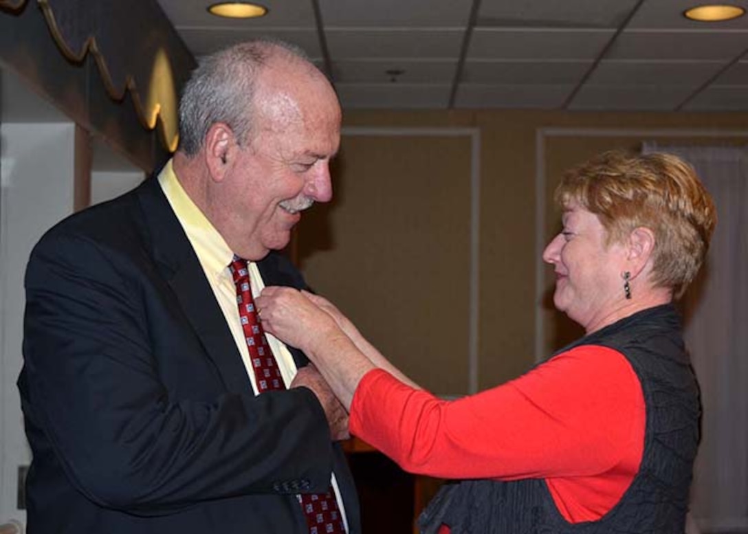 Donald Tracy, deputy chief counsel, Defense Logistics Agency Counsel – Aviation is pinned into retirement by his wife, Lorraine, during his retirement ceremony Sept. 29, 2016 at Defense Supply Center Richmond, Virginia. Tracy, who served as a federal attorney with DLA since 1980, is published in 39 reported decisions of the Armed Services Board of Contract Appeals, and as co-counsel in 21 published decisions in federal court.  He retires after 36 years of federal service. 