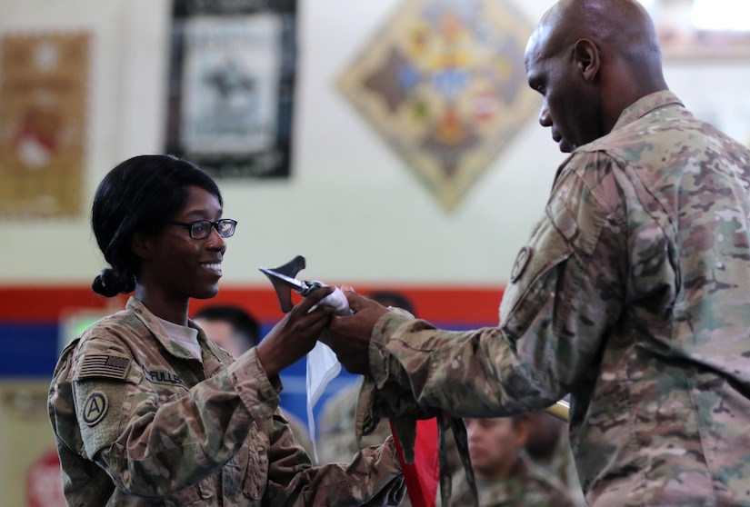 Capt. Doreen D. Fuller, Third Army Augmentation Company commander, cases the Third Army Augmentation Company colors for the final time with Sgt. 1st Class Curtis Williams, who stood in as the acting 1st Sergeant for Augmentation Company 1st Sgt. Kenneth Lewis, during an inactivation ceremony Sept. 28, 2016 at Camp Arifjan, Kuwait. The company has supported U.S. Army Central for more than 27 years in Kuwait. (U.S. Army photo by Sgt. Brandon Hubbard, USARCENT Public Affairs)
