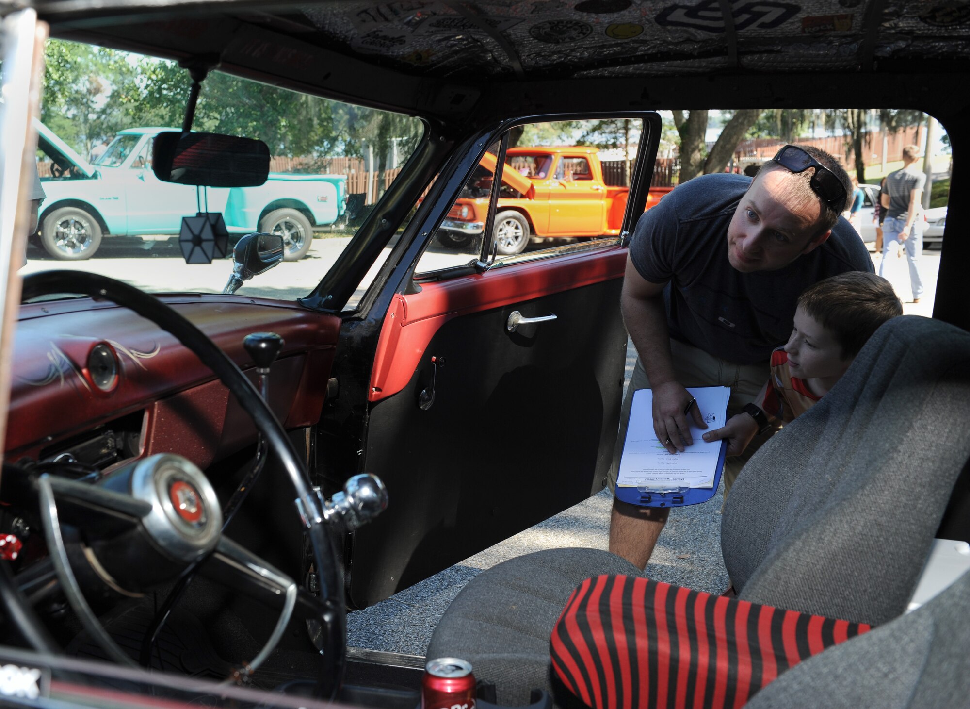 Tech. Sgt. Jimmy Quillen, 2nd Air Force technical training analyst and Cruisin Keesler judge, and his son, Logan, inspect the inside of a 1953 Ford Custom Line at marina park during the Cruisin’ Keesler 13th Annual Car Show Oct. 1, 2016, on Keesler Air Force Base, Miss. There were over 130 classic car, truck, bike and hot rod entries with more than 40 awards presented. (U.S. Air Force photo by Kemberly Groue/Released)