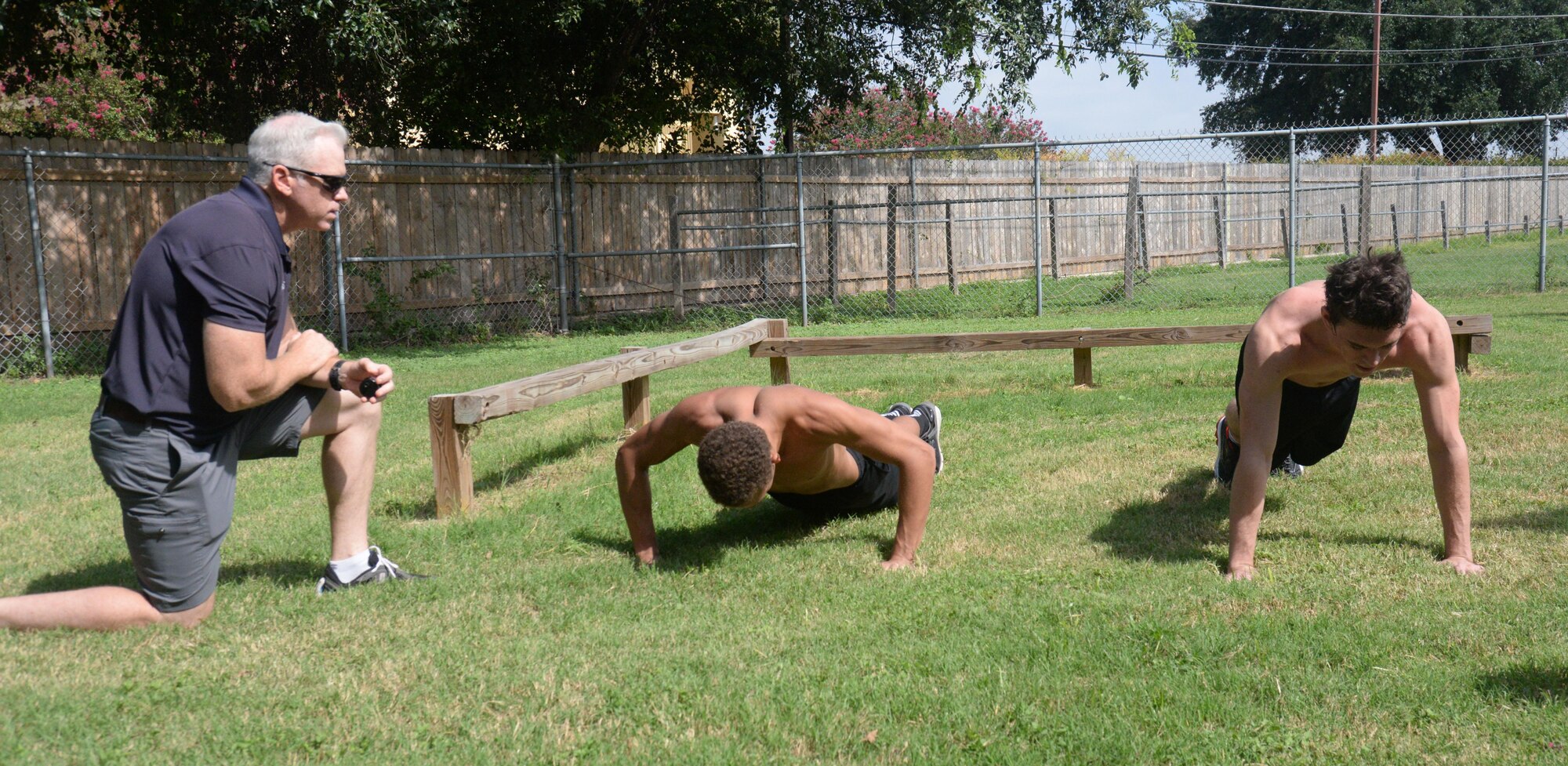 Steve Barrons, Air Force Special Operations developer, looks over candidates Craig Smith and Jon Benge as they perform their push-ups during the Physical Ability and Stamina Test in San Antonio, Texas, Sept. 8. 