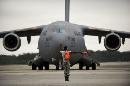 A maintainer from the 437th Air Craft Maintenance Squadron marshals out a Joint Base Charleston C-17 Globemaster III as it is evacuated to Fort Campbell, KY on Oct. 6, 2016 to continue the mission of rapid global mobility during Hurricane Matthew. Due to Hurricane Matthew, a Limited Evacuation Order of South Carolina Hurricane Evacuation Zones was issued by the Commander, Joint Base Charleston. All Joint Base personnel are expected to evacuate the area and will return once damage is assessed and it’s safe to return. 