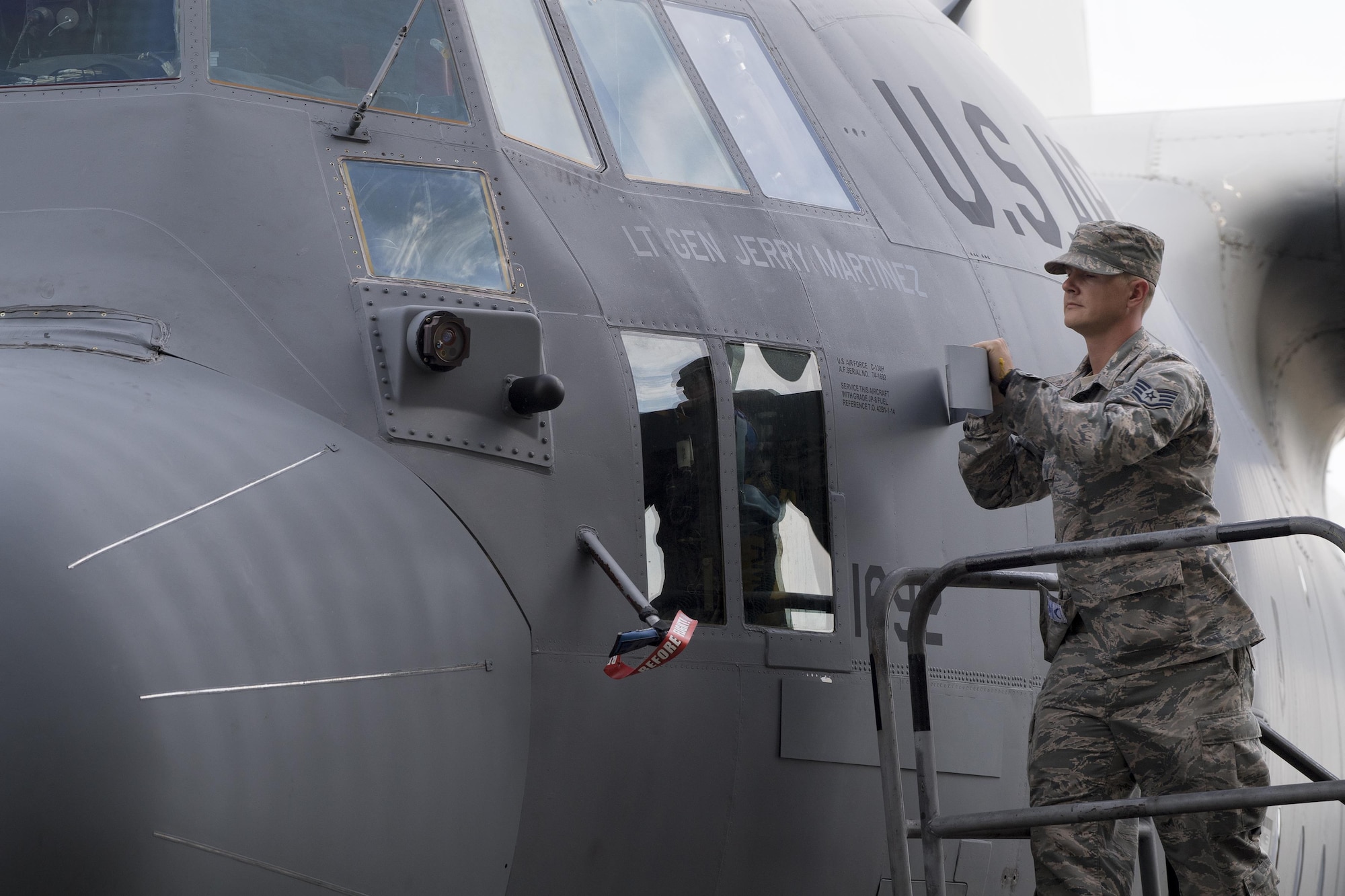 Staff Sgt. Kenneth Sutton, 374th Aircraft Maintenance Squadron crew chief, unveils the name of the incoming United States Forces, Japan and 5th Air Force commander, on a C-130H Hercules at Yokota Air Base, Japan, Oct. 6, 2016, during the assumption of command ceremony. (U.S. Air Force photo by Yasuo Osakabe/Released) 