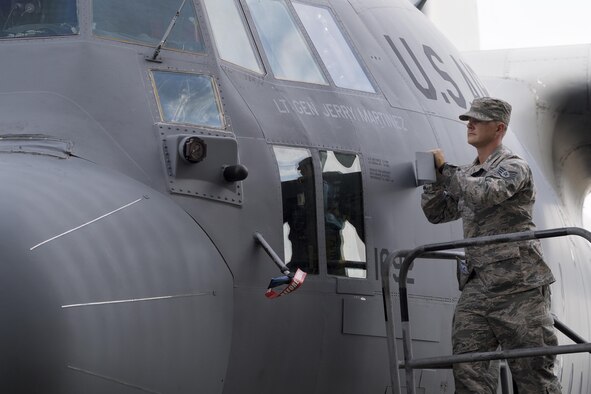 Staff Sgt. Kenneth Sutton, 374th Aircraft Maintenance Squadron crew chief, unveils the name of the incoming United States Forces, Japan and 5th Air Force commander, on a C-130H Hercules at Yokota Air Base, Japan, Oct. 6, 2016, during the assumption of command ceremony. (U.S. Air Force photo by Yasuo Osakabe/Released) 