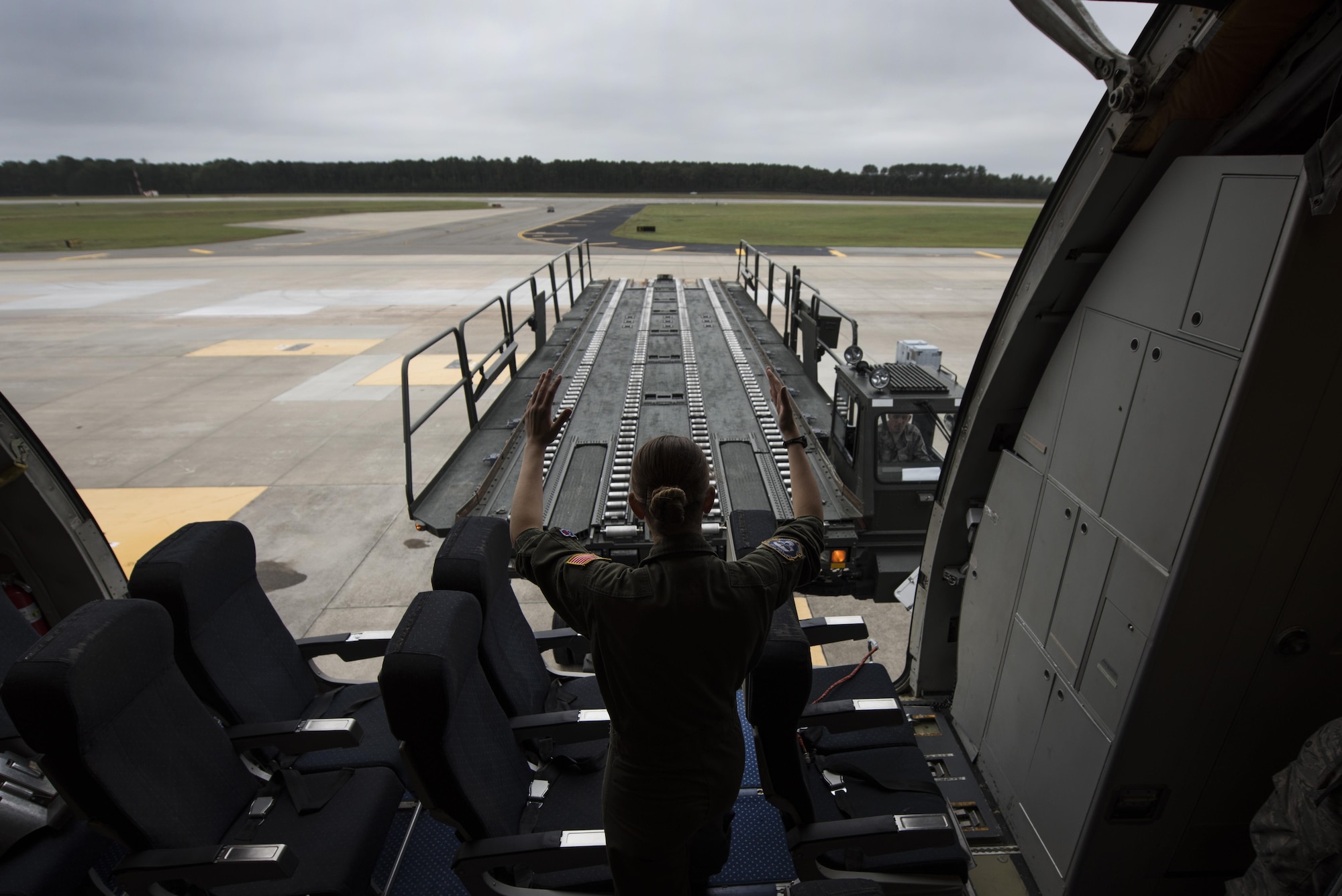 Senior Airman Hannah Byers, 32nd Air Refueling Squadron crew chief, marshals a K-Loader into position, Oct. 6, 2016, at Seymour Johnson Air Force Base, North Carolina. A KC-10A Extender arrived from Joint Base McGuire-Dix-Lakehurst, New Jersey, to help move essential equipment as more than 40 F-15E Strike Eagles and six KC-135R Stratotanker aircraft were repositioned to Barksdale Air Force Base, Louisiana, as a precautionary measure to avoid potential damage from high winds associated with Hurricane Matthew. (U.S. Air Force photo by Senior Airman Brittain Crolley)