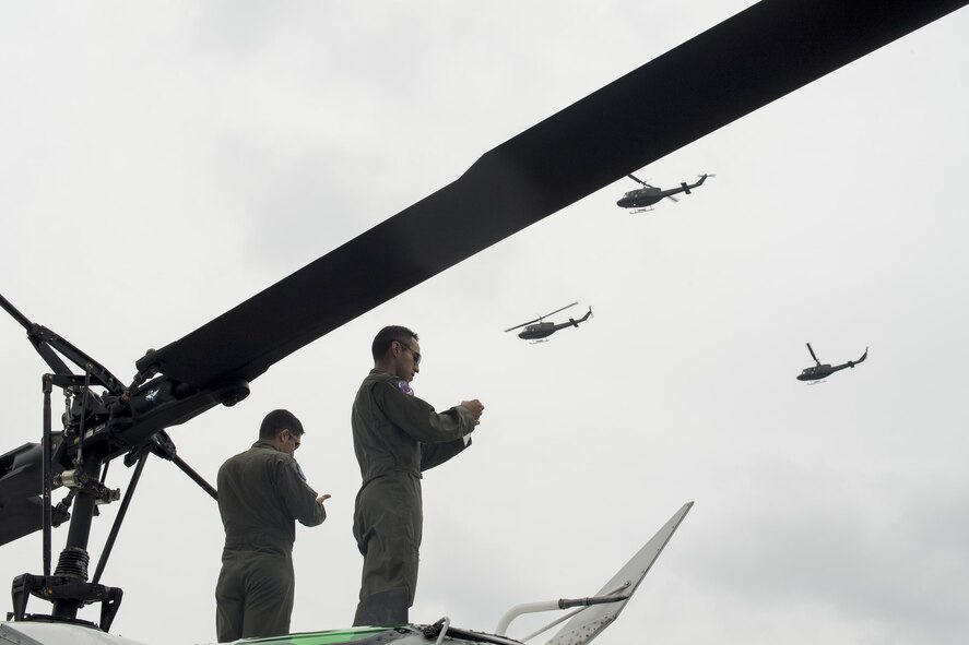 (Right to left) U.S. Air Force Capt. Jonathan Bonilla and Capt. Vicente Vasquez, 459th Airlift Squadron UH-1N Iroquois pilots, take photos of a Japan Ground Self-Defense Force UH-1J Huey formation flight display during the 43rd Anniversary Event of Japan Ground Self-Defense Force Camp Tachikawa at JGSDF Camp Tachikawa, Japan, Oct. 1, 2016.  JGSDF UH-1Js assigned to Eastern Army Helicopter demonstrated flight formations, hoist techniques and disaster relief procedures with first responders. Service members with the 459th Airlift Squadron from Yokota Air Base and Army Aviation Battalion from Camp Zama participated in the festival. (U.S. Air Force photo by Yasuo Osakabe/Released) 