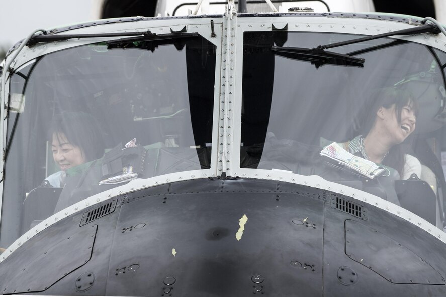 Festivalgoers sit the cockpit of a U.S. Air Force UH-1N Iroquois helicopter during the 43rd Anniversary Event of Japan Ground Self-Defense Force Camp Tachikawa at JGSDF Camp Tachikawa, Japan, Oct. 1, 2016. Service members with the 459th Airlift Squadron from Yokota Air Base and Army Aviation Battalion from Camp Zama participated in the festival. (U.S. Air Force photo by Yasuo Osakabe/Released)