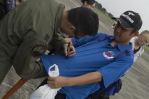 U.S. Air Force Capt. Jonathan Bonilla, 459th Airlift Squadron UH-1N pilot, autographs a t-shirt for a festivalgoer during the 43rd Anniversary Event of Japan Ground Self-Defense Force Camp Tachikawa at JGSDF Camp Tachikawa, Japan, Oct. 1, 2016. Service members with the 459th Airlift Squadron from Yokota Air Base and Army Aviation Battalion from Camp Zama participated in the festival. (U.S. Air Force photo by Yasuo Osakabe/Released)