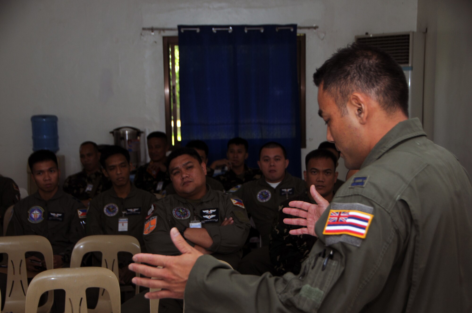 U.S. Air Force Capt. Brandon Chang assigned to the 204th Airlift Squadron explains select aspects of U.S. Air Force aircraft to pilots of the Philippine Air Force during a State Partership Program subject matter expert exchange at Basa Air Base, Philippines, Aug. 24, 2016. The State Partnership Program is a National Guard program that links a state's national guard with a partner country to help build capacity and security cooperation. (U.S. Air National Guard photo by Senior Airman Orlando Corpuz/released) 