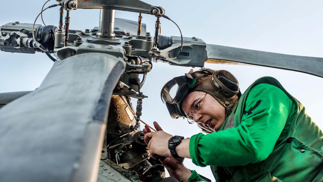 Navy Petty Officer 2nd Class Bobby Larose repairs a wire on a chip detector in the tail rotor gear box of an MH-60R Seahawk helicopter on the flight deck of the USS Ronald Reagan in the Philippine Sea, Oct. 5, 2016. The aircraft carrier is supporting security and stability in the Indo-Asia-Pacific region. Navy photo by Petty Officer 3rd Class Nathan Burke