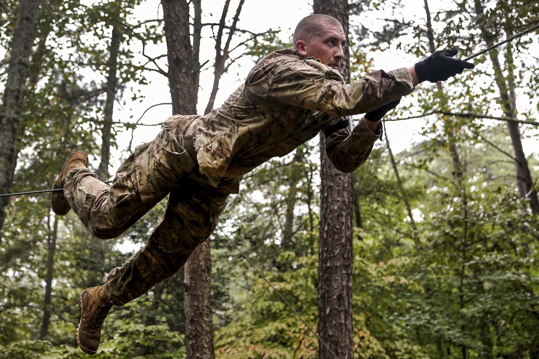 Army Staff Sgt. Andrew Crump pulls himself along a high rope obstacle during the Army's 2016 Best Warrior Competition at Fort A.P. Hill, Va., Sept. 27, 2016. Crump is assigned to the U.S. Army Cyber Command. Army photo by Pfc. Jada Owens