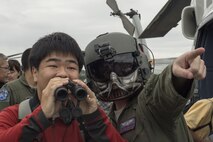U.S. Air Force Tech. Sgt. David Jacob, 459th Airlift Squadron flight engineer, directs a festivalgoer’s attention during the 43rd Anniversary Event of Japan Ground Self-Defense Force Camp Tachikawa at JGSDF Camp Tachikawa, Japan, Oct. 1, 2016.  Service members with the 459th Airlift Squadron, Yokota Air Base and Army Aviation Battalion, Camp Zama, participated in the festival. The festival displayed helicopters assigned to JGSDF, Japan Maritime Self-Defense Force, the Metropolitan Police Department, Tokyo Fire Department and Japanese Red Cross. (U.S. Air Force photo by Yasuo Osakabe/Released) 