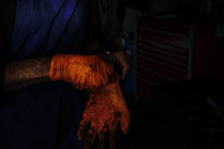 Retired Air Force Master Sgt. Greg Hermann, 86th Force Support Squadron tire technician at the Auto Hobby Shop at Ramstein Air Base, Germany, dons his gloves as he prepares for work Sept. 28, 2016. He has worked at Ramstein since April, but carries over 40 years of auto mechanic experience with him. (U.S. Air Force photo by Airman 1st Class Lane T. Plummer) 