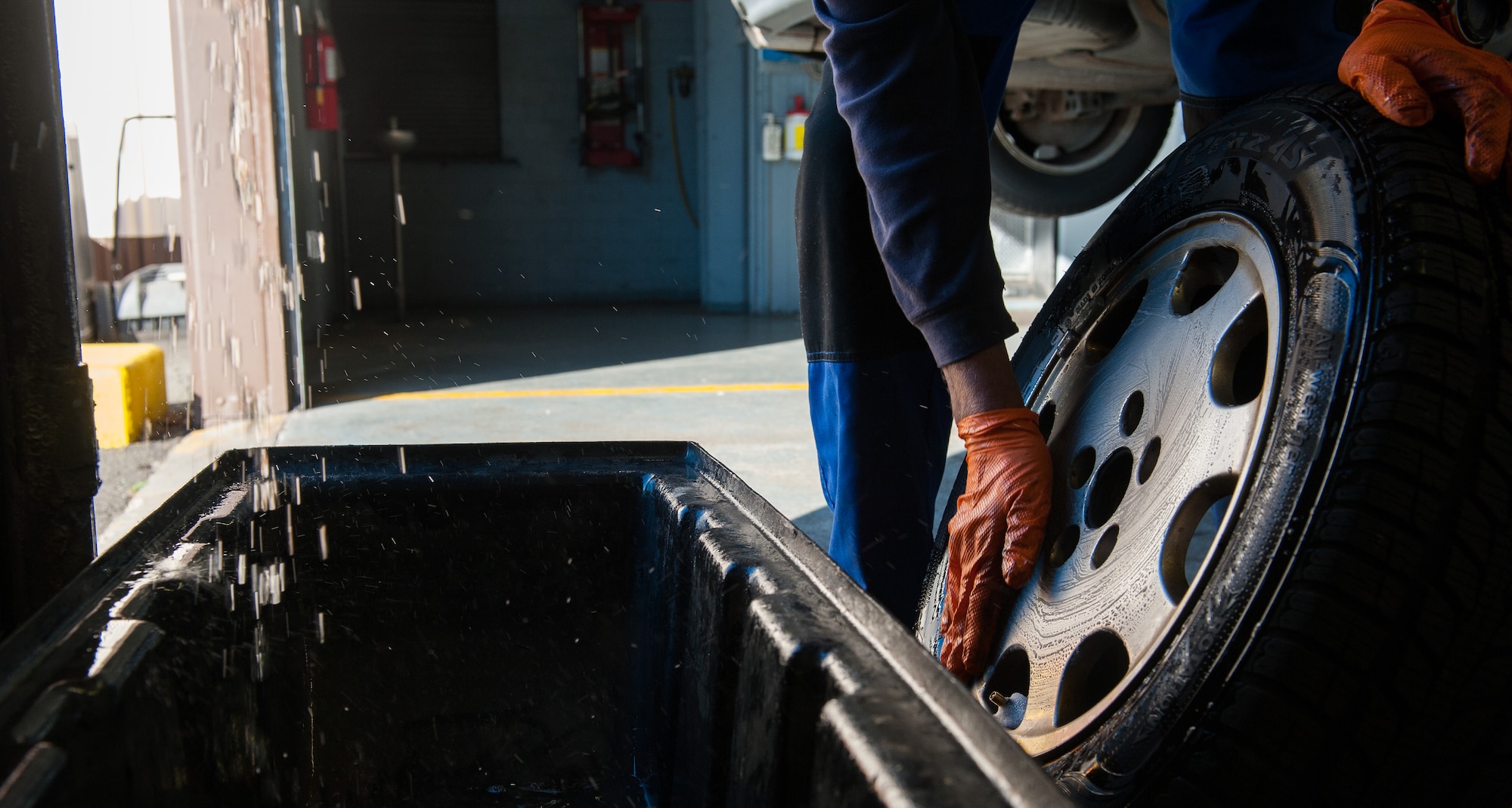 Retired Air Force Master Sgt. Greg Hermann, 86th Force Support Squadron Auto Hobby Shop tire technician, washes a vehicle’s wheel at Ramstein Air Base, Germany, Oct. 5, 2016. To test for air leaks in a tire, Hermann washes the wheel with soap and water, and looks for pockets of air bubbles, an indicator that air is leaking out. (U.S. Air Force photo by Airman 1st Class Lane T. Plummer)