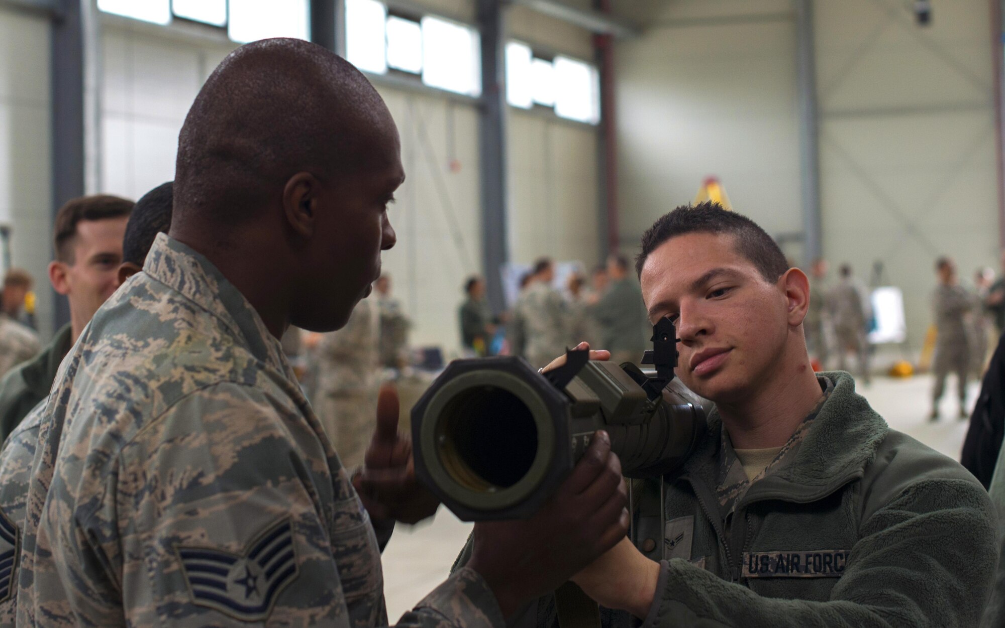 Staff Sgt. Julius Taylor, 435th Security Forces Squadron combat arms instructor, shows Airman 1st Class Victor Ortega, 603rd Air Operations Center intelligence analyst, how to use an AT4 rocket launcher at Ramstein Air Base, Germany, Oct. 6, 2016. The rocket launcher is an 84-mm unguided, portable, single-shot weapon designed as an assault weapon against buildings and fortifications. (U.S. Air Force photo by Senior Airman Tryphena Mayhugh)