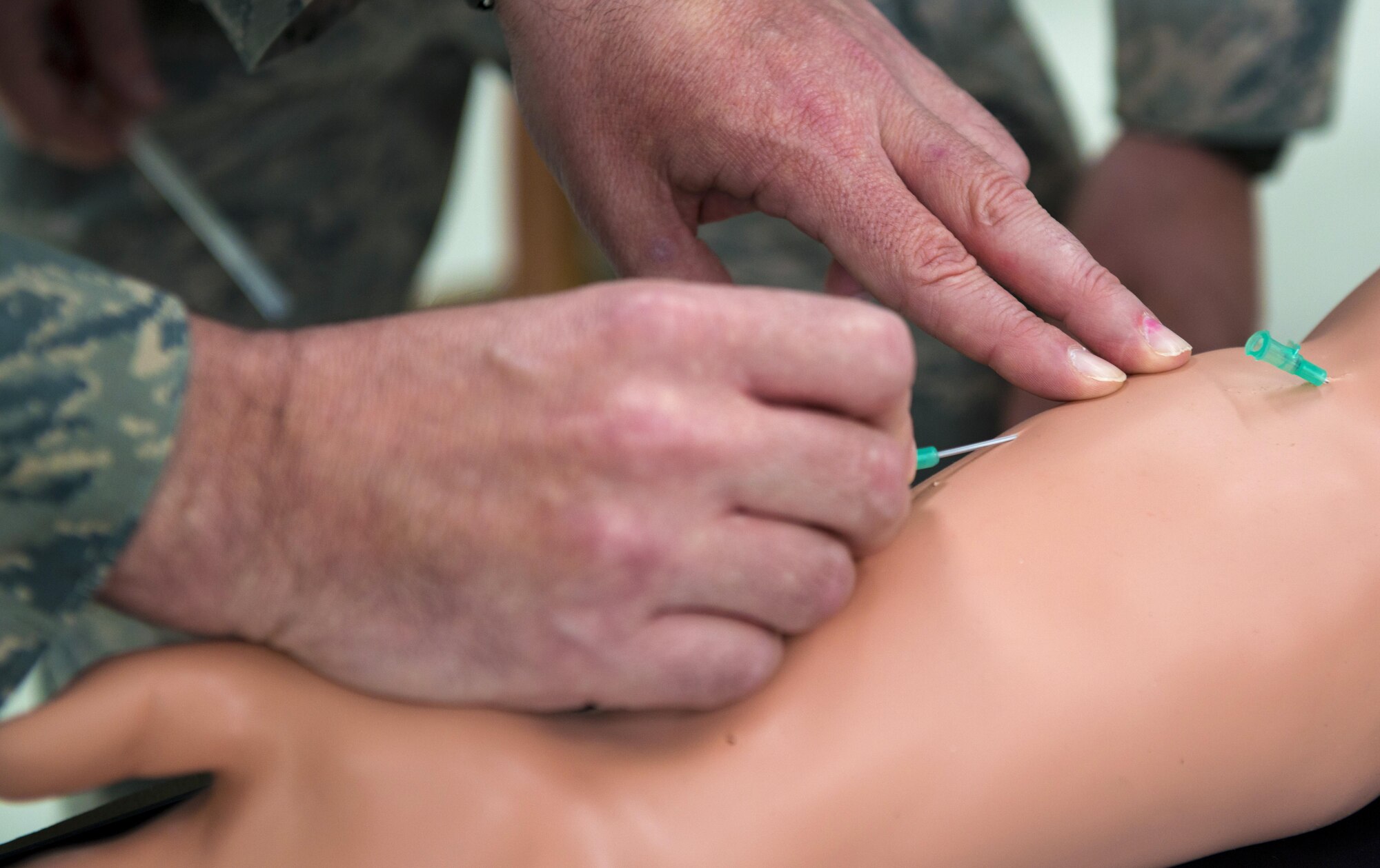 Chief Master Sgt. Ed Keenan, 435th Contingency Response Group superintendent, sticks an intravenous needle into a dummy’s arm while visiting the 435th CRG booth during the 435th Air Ground Operations Wing’s open house at Ramstein Air Base, Germany, Oct. 6, 2016. The open house provided a venue for leaders at Ramstein to gain a better understanding of the wing’s equipment and capabilities. (U.S. Air Force photo by Senior Airman Tryphena Mayhugh)