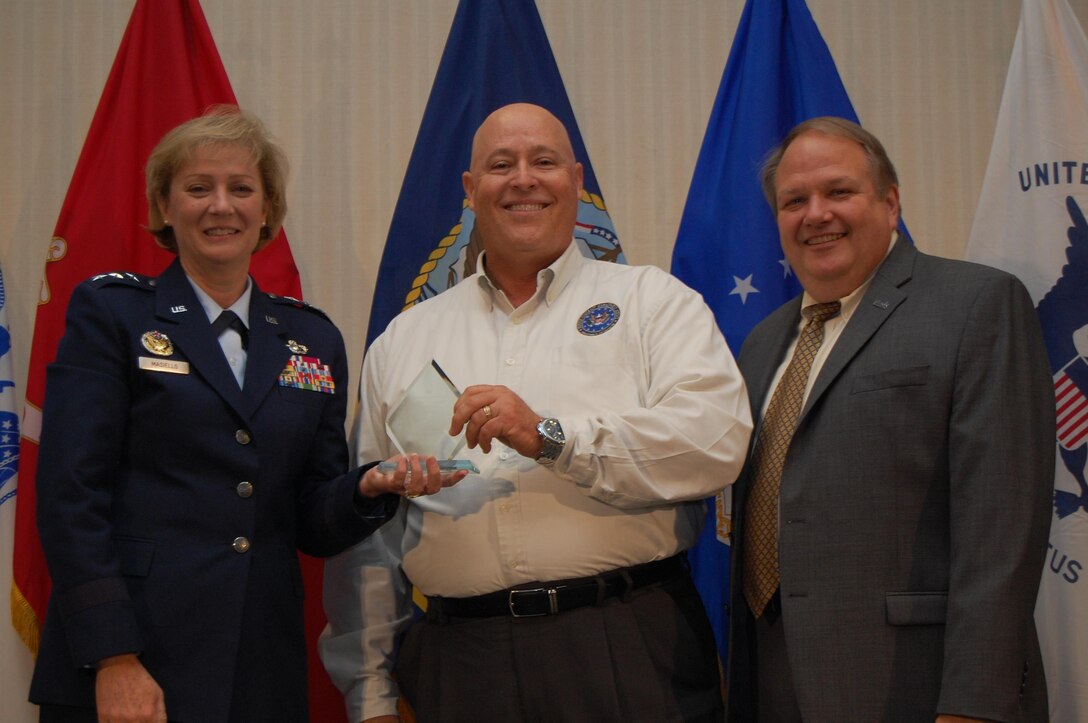 Defense Contract Management Agency Director Air Force Lt. Gen. Wendy Masiello and James Russell, deputy director, congratulate Keith Kalbfleisch at the agency’s Worldwide Training Conference in June on receiving the 2016 Outstanding Personnel of the Year award for his work on developing an idea to automate Program Assessment Reports. Kalbfleisch, the engineering and manufacturing director at DCMA Lockheed Martin Orlando, and others from around the agency, provided input and lessons learned to create a faster and better way to provide the timely reports to customers. (DCMA photo by Tonya Johnson) 

