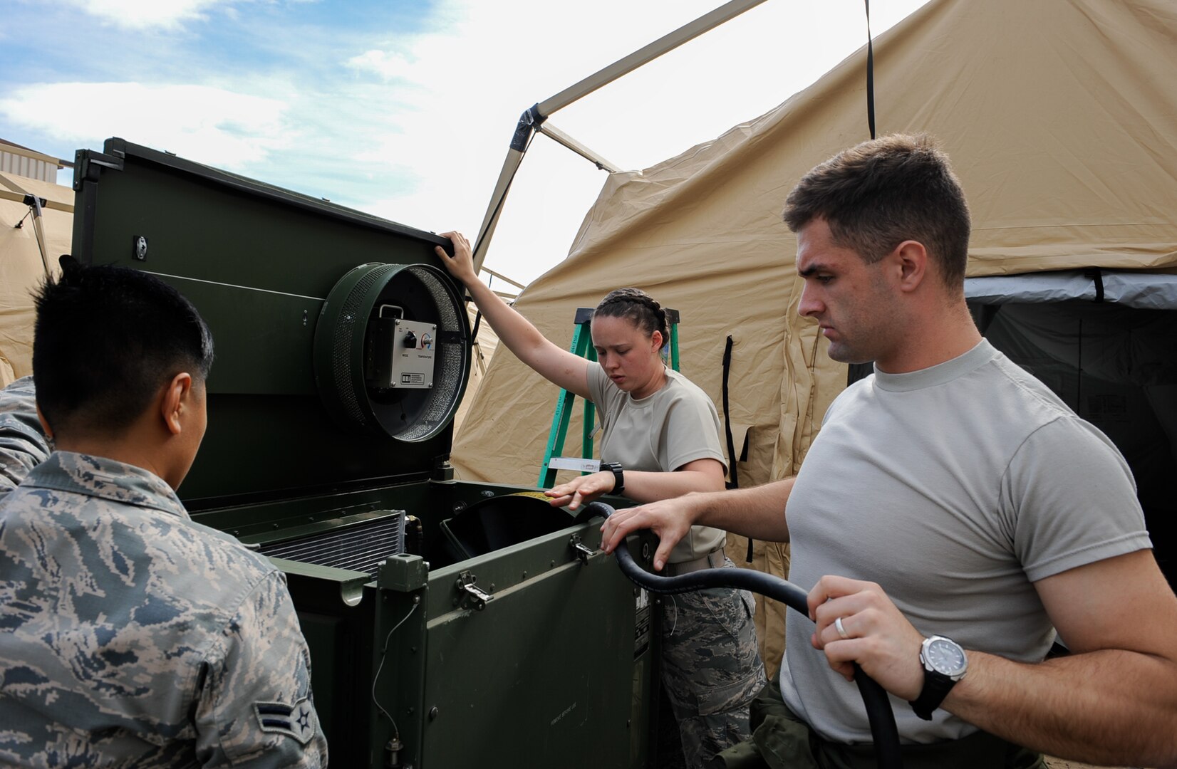 Airman 1st Class Alexa Fagaragan (left), and Airman Robyn Nelson (middle), 86th Medical Support Squadron war reserve material technicians, hook an air conditioning unit to a generator to dry out tents with Staff Sgt. Tyler Wilson (right) , 86th MDSS WRM supervisor at Ramstein Air Base, Germany, Sept. 28, 2016. The tents were used during Exercise Immediate Response 2016 in Slovenia from Sept. 9 to 23. Immediate Response 2016 was an exercise that tested a rapid response for aeromedical evacuation operations. (U.S. Air Force photo by Airman 1st Class Savannah L. Waters)