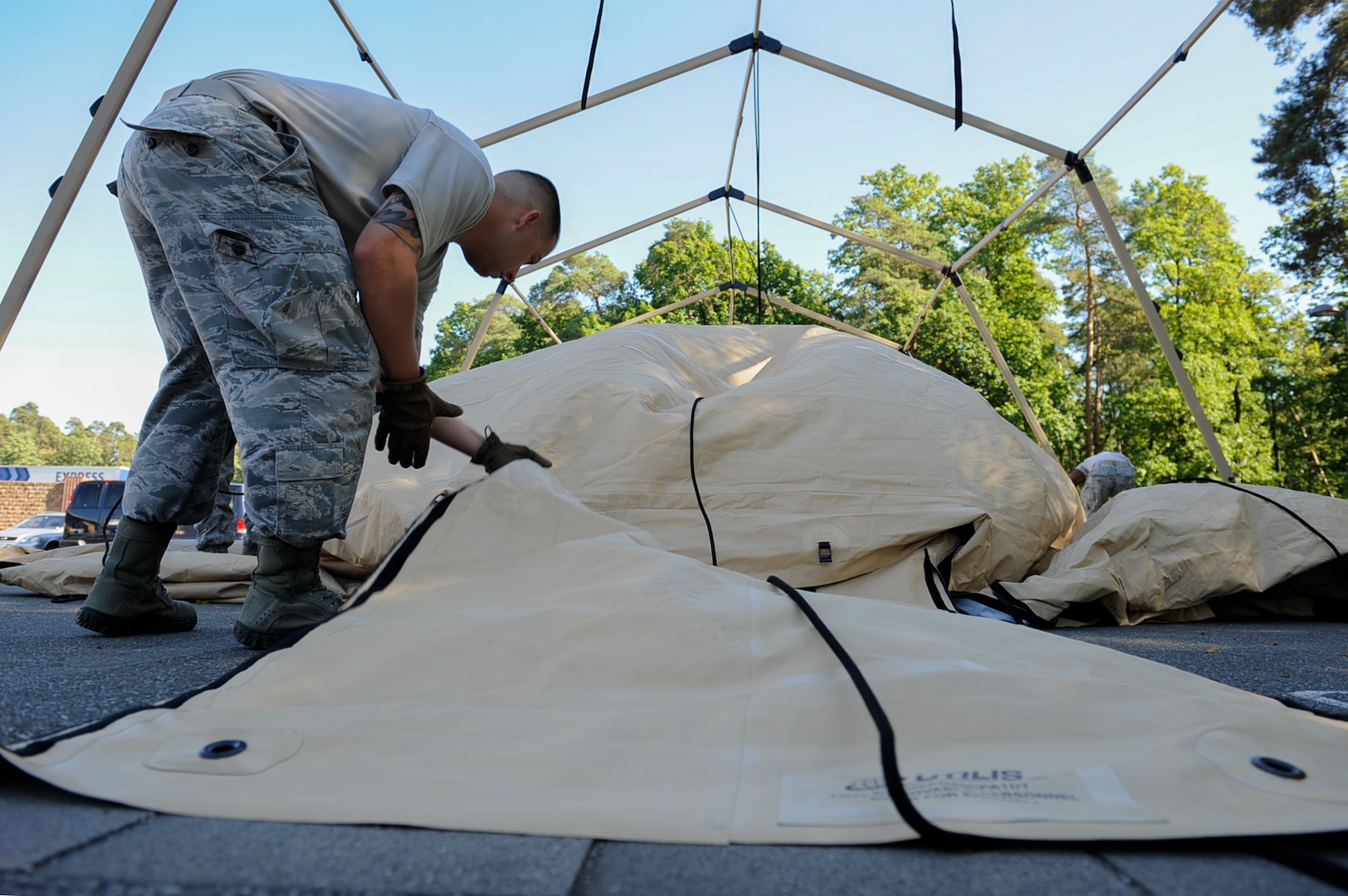 Staff Sgt. Franklin Dover, 86th Medical Support Squadron war reserve material crew chief, straightens the door of a tent being cleaned at Ramstein Air Base, Germany, Sept. 29, 2016. WRM technicians are responsible for the maintenance and inventory of medical supplies.  (U.S. Air Force photo by Airman 1st Class Savannah L. Waters)