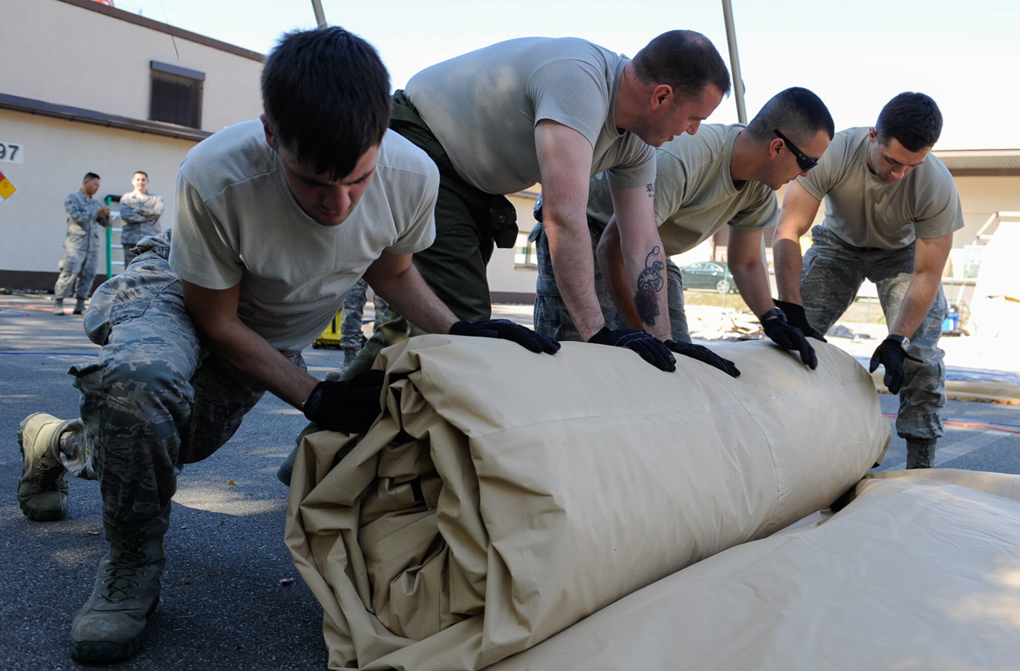 Airmen from the 86th Medical Support Squadron roll a tent at Ramstein Air Base, Germany, Sept. 29, 2016. The tent had been used during Exercise Immediate Response 2016 in Slovenia, an exercise that over 2,000 participants from 11 different countries, including the U.S., attended. (U.S. Air Force photo by Airman 1st Class Savannah L. Waters)