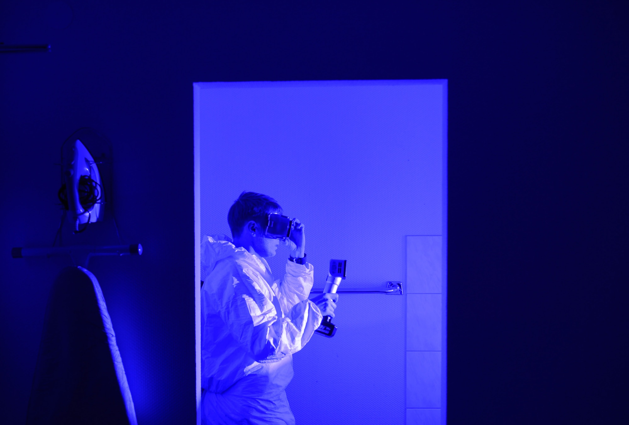 An Air Force Office of Special Investigations 4th Field Investigations Squadron agent utilizes an alternate light source during a mock crime scene at Ramstein Air Base, Germany, Oct. 6, 2016. Agents utilize light sources to search for biological fluids undetectable to the naked eye. The 4th FIS facilitate surprise mock crime scenes for six units within U.S Air Forces in Europe in order to assess agents’ techniques and readiness. (U.S. Air Force photo by Senior Airman Nesha Humes)