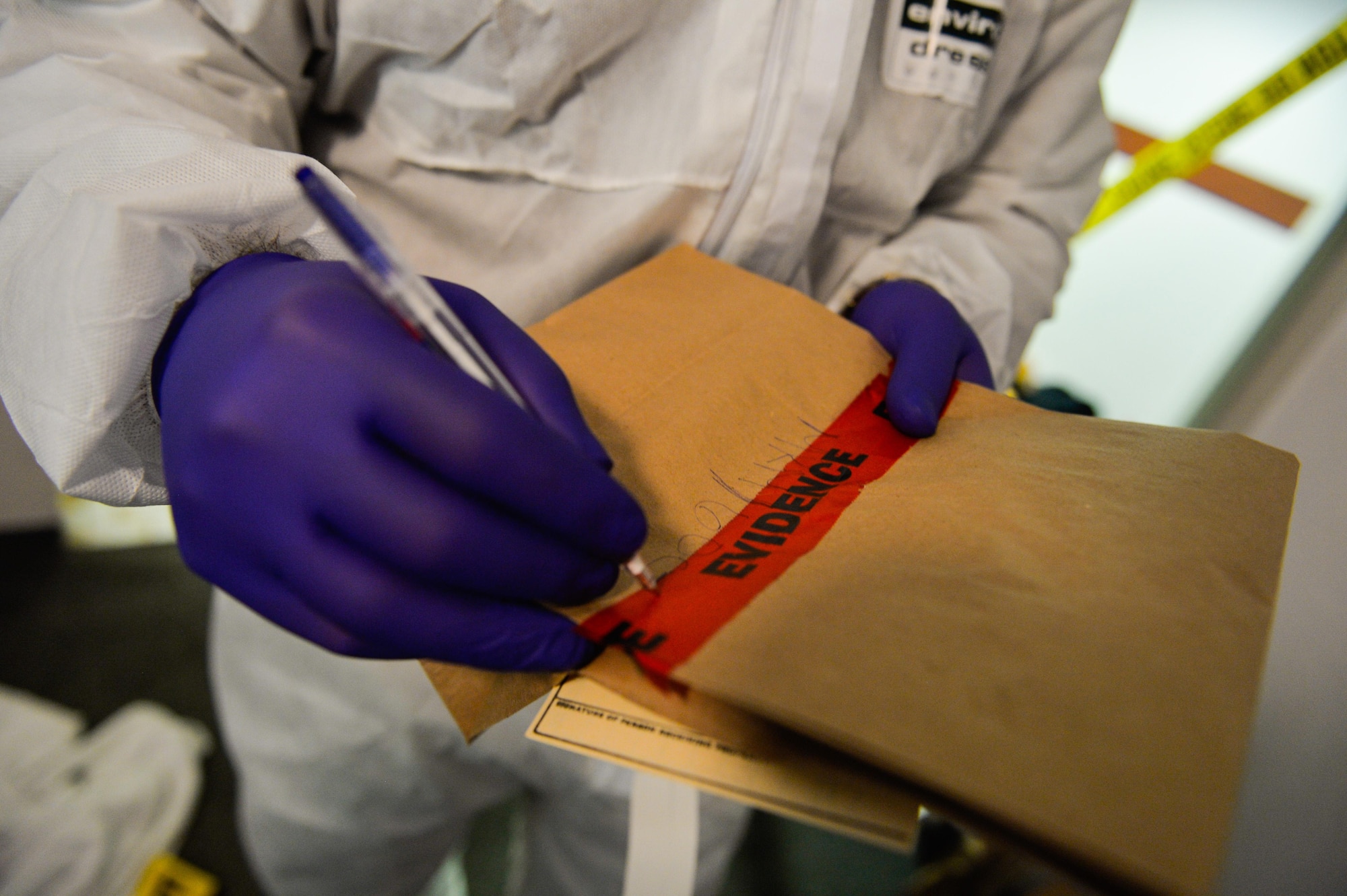 An Air Force Office of Special Investigations 13th Field Investigations Squadron agent writes on an evidence bag during a mock crime scene at Ramstein Air Base, Germany, Oct. 6, 2016.  The mock crime scenes are treated as real-world events, often times involving security forces, medical personnel and role players as victims. The 4th FIS facilitate surprise mock crime scenes for six units biannually within U.S Air Forces in Europe. (U.S. Air Force photo by Senior Airman Nesha Humes)