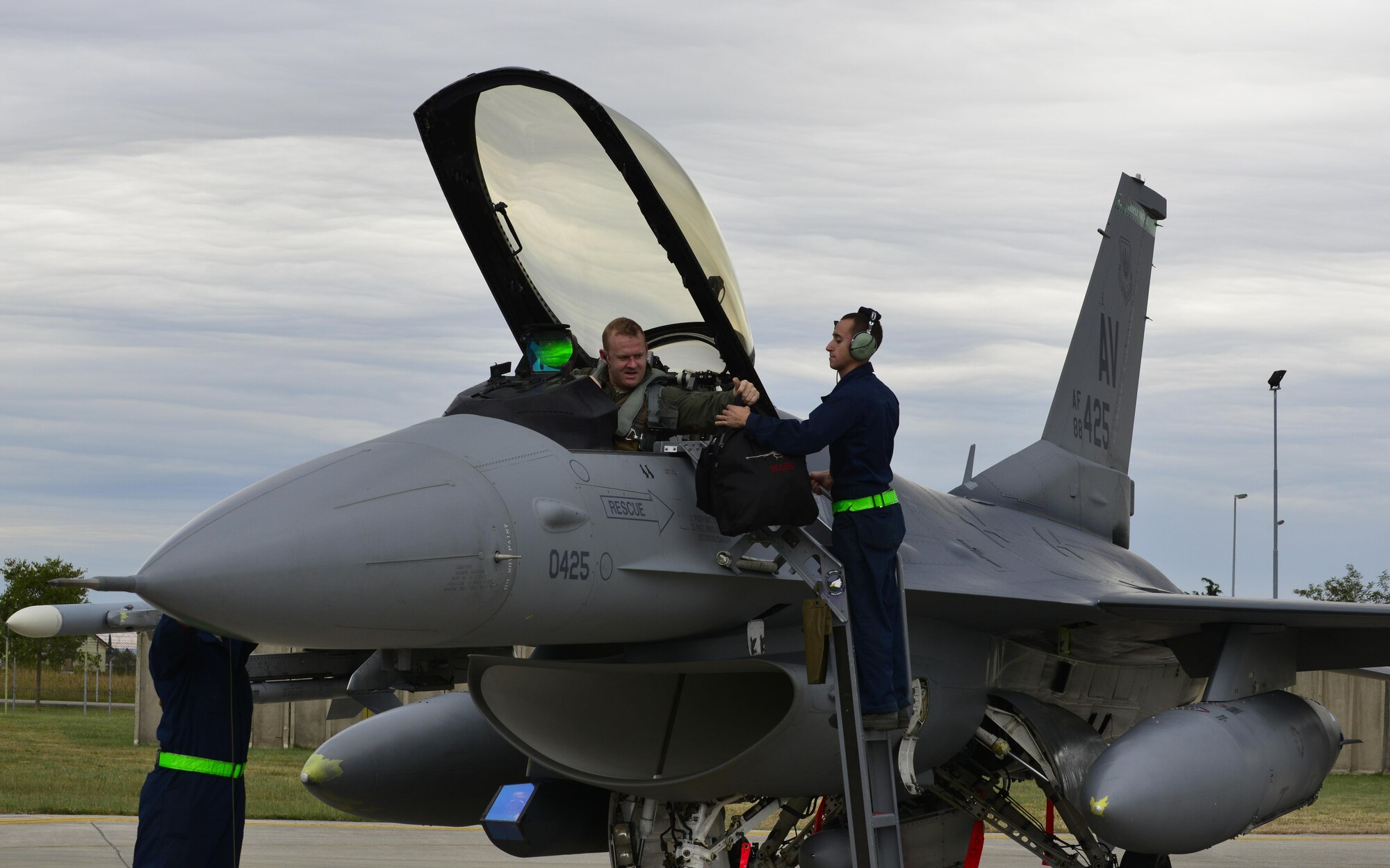 Airman 1st Class Nicholas Goncalves, 31st Aircraft Maintenance Squadron crew chief, takes equipment from Capt. Nathan Skavdal, 555th Fighter Squadron F-16 Fighting Falcon pilot, before starting his end-of-flight inspection on the aircraft at Aviano Air Base, Italy on Oct. 5, 2016. Airmen from the 31st AMXS inspect aircraft for physical, electrical and environmental defects to ensure the aircraft stays mission ready. (U.S. Air Force photo by Senior Airman Krystal Ardrey/Released)