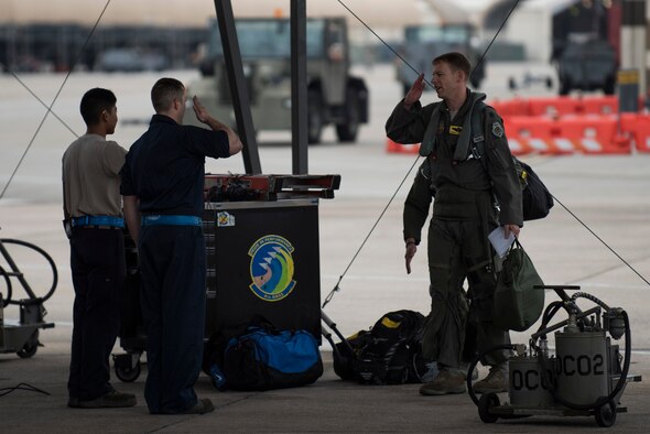 Maintainers and aircrew greet each other before generating an F-15E Strike Eagle to depart the area as a precautionary measure due to Hurricane Matthew, Oct. 6, 2016, at Seymour Johnson Air Force Base, North Carolina. More than 40 F-15E Strike Eagles and six KC-135R Stratotanker aircraft repositioned to Barksdale Air Force Base, Louisiana, to avoid potential damage from high winds and rain associated with Matthew. (U.S. Air Force photo by Senior Airman Brittain Crolley)