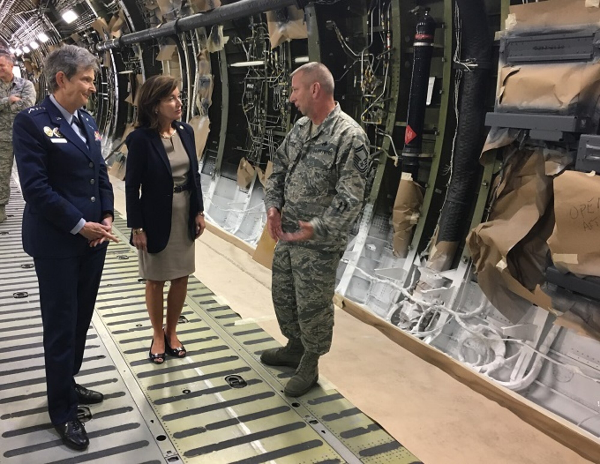 Senior Master Sgt. Dennis Pitcher briefs Gen. Ellen Pawlikowski, Air Force Materiel Command  commander, and New York Lieutenant Governor Kathy Hochul on the C-5M interior refurbishment mission Oct. 5 at Stewart Air National Guard Base, N.Y.  Airmen from the 105th Airlift Wing at Stewart spend approximately 40 days repainting aircraft interior, adding a new, non-skid cargo deck, replacing cargo compartment and flight deck insulation, replacing 2,400 decals and other aesthetic upgrades.  The work at Stewart represents the final step in the C-5M conversion, which includes glass cockpit, new engines and reliability and performance enhancements to extend the life and capabilities of the airlifter. (U.S. Air Force photo/Derek Kaufman)