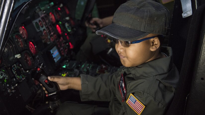 Kwami Penty flies in an UH-1 Iroquois simulator as part of the “Pilot for a Day” program at Joint Base Andrews, Md., Oct. 6, 2016. The event is held biannually for children battling serious illnesses. In addition to flying in simulators, Kwami spent the day participating in demonstrations and touring static aircraft displays. (U.S. Air Force photo by Senior Airman Jordyn Fetter)