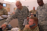 Florida National Guard Soldiers 1st Sgt Timothy Smith, Capt. Kirk Strander and CW2 Joseph McKire discuss hurricane response at the Joint Operations Center during Hurricane Matthew.