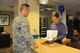 (Right) Tom Wallis, 926th Wing financial management lead defense travel administrator, helps a new member with their in-processing checklist. 