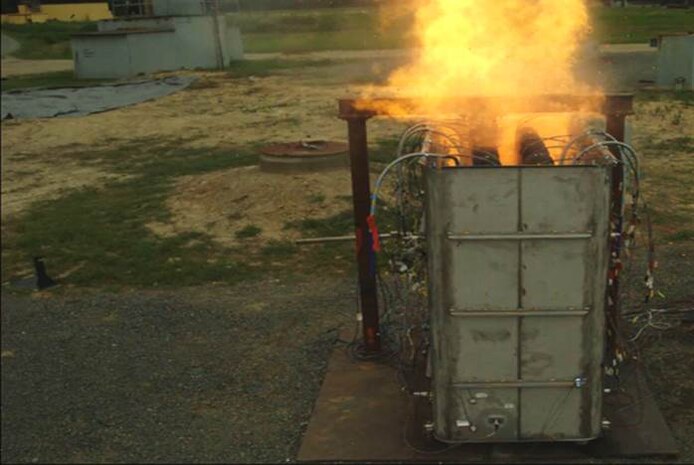 A Longbow Hellfire Missile rocket motor burns while being restrained within the container during a test of the Missile Exhaust Containment Structure at Naval Surface Warfare Center Dahlgren Division's Explosive Experimental Area. The restrained missile firing test is designed to duct missile exhaust and fire through plenum exhaust chambers in the top of the LCS Surface-to-Surface Missile Module. 