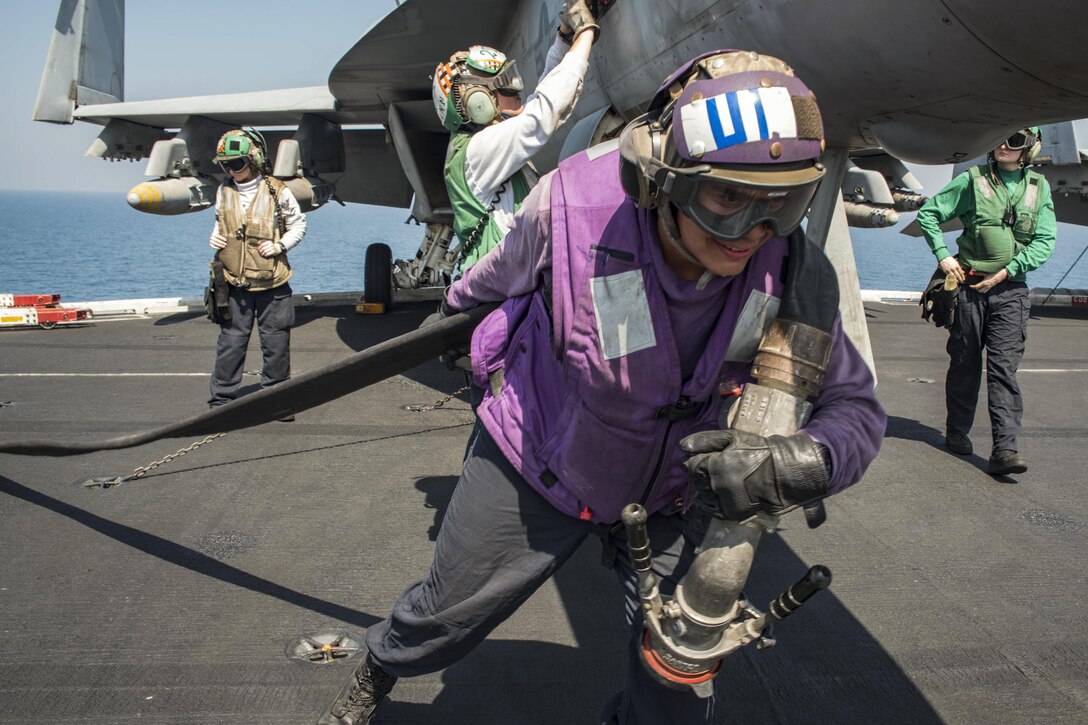 Navy Seaman Eddy Ramirez brings a refueling hose onto the flight deck of the USS Dwight D. Eisenhower in the Persian Gulf, Oct. 6, 2016. The aircraft carrier is supporting Operation Inherent Resolve and other security efforts in the U.S. 5th Fleet area of responsibility. Ramirez is an aviation boatswain's mate on the Eisenhower. Navy photo by Seaman Joshua Murray
