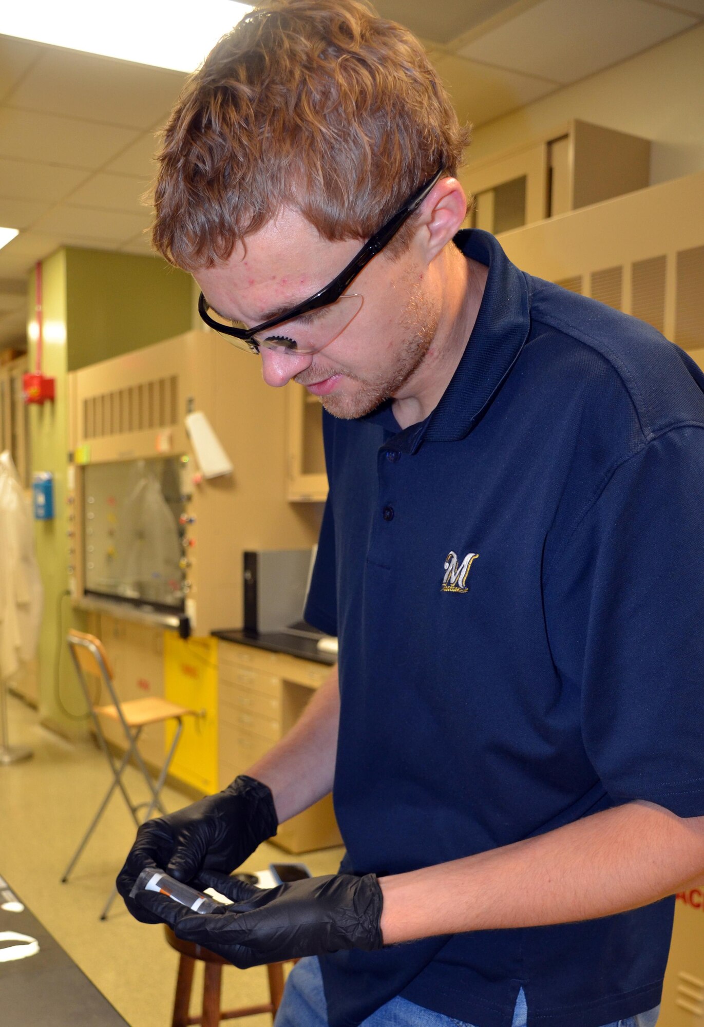 A researcher at Air Force Research Laboratory demonstrates the ability of a flexible lithium-ion battery to conform under stress. The batteries developed here have proven themselves to maintain steady voltage even after exposure to more than 250 rounds of extreme mechanical manipulations. (U.S. Air Force photo by Marisa Alia-Novobilski/released) 