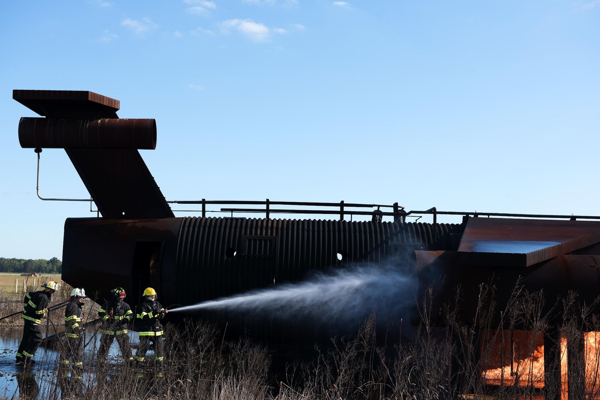 Chief Master Sgt. Poling, Roderick Davis, Senior Airman William Hough and Airman 1st Class Charles Ramirez Johnson, extinguish a fire on a mock aircraft at Joint Base McGuire-Dix-Lakehurst, N.J. Oct. 6. Polling, Davis and Hough had the opportunity to experience the training at the start of National Fire Prevention Week. Polling is the 87th Air Base Wing command chief, Davis is the 87th ABW executive director, Hough is 87th ABW wing executive staff and Ramirez Johnson is a 87th Civil Engineer Squadron firefighter apprentice. 