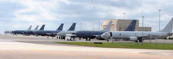 Four Navy P-8 Poseidon aircraft from Naval Air Station Jacksonville, Florida, line up with Air Force KC-135 Stratotankers on Tinker Air Force Base’s flightline Oct. 6. The P-8s, along with seven other Navy aircraft, sought shelter from Hurricane Matthew here. (Air Force photo by April McDonald)