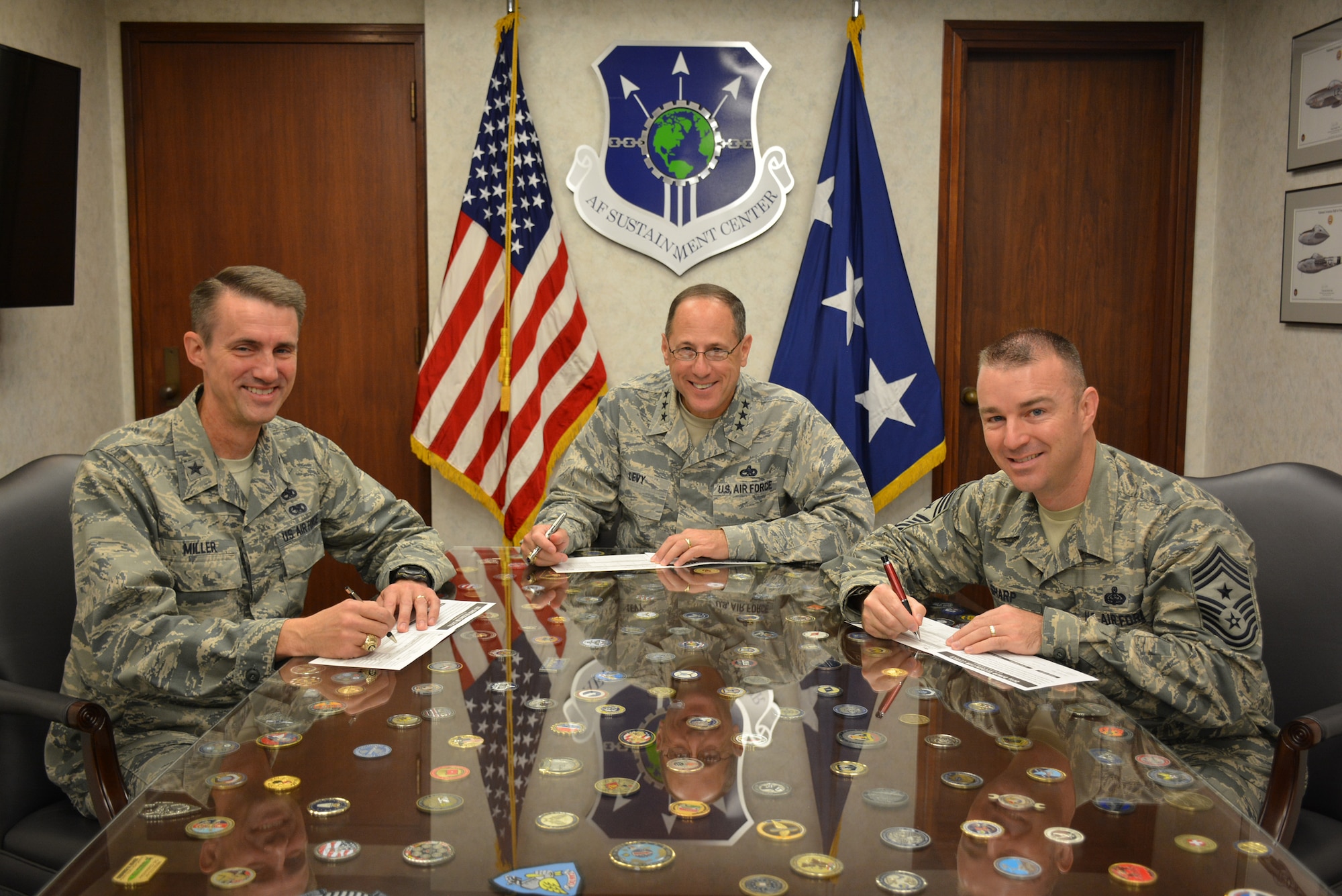 On Oct. 7, Air Force Sustainment Center senior leaders take time to fill in their pledge cards to signal the start of the Combined Federal Campaign, which began Oct. 3 and runs through Nov. 17. Filling in their pledge cards are Lt. Gen. Lee K. Levy II, AFSC commander, center, Brig. Gen. Tom Miller, AFSC vice commander, left, and AFSC Command Chief Master Sgt. Gary Sharp. The CFC is one of only two official fundraisers approved each year for Department of Defense employees. This year’s theme is “Camp CFC – Let the CAMPaign Begin.” (Photo by Darren D. Heusel)