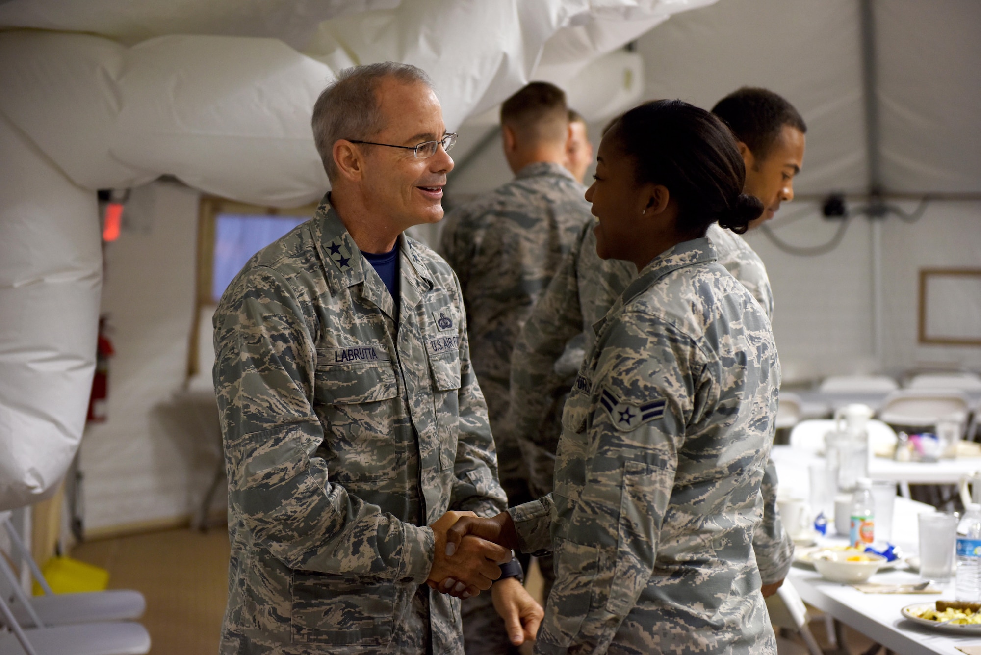 U.S. Air Force Maj. Gen. Bob LaBrutta, 2nd Air Force Commander, shakes hands with Airman 1st Class Audacity Harris, 17th Comptroller Squadron financial technician, at the Cressman Dining Facility temporary annex on Goodfellow Air Force Base, Texas, Oct. 7, 2016. LaBrutta came for a two-day base tour and ate breakfast with junior-enlisted Airmen on Friday morning. (U.S. Air Force photo by Airman 1st Class Chase Sousa/Released)