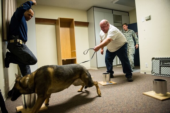 Jerry Houston, International Health Care Security, reacts as his working dog, Axa, is rewarded for successfully detecting homemade explosives Oct. 5 at Hill Air Force Base. The training consisted of explosive compound awareness for handlers and trainers, imprint training for dogs, and detection testing for teams. (U.S. Air Force photo by R. Nial Bradshaw)