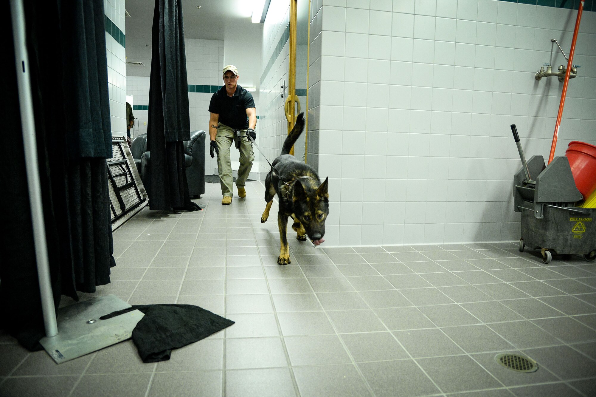 Staff Sgt. Dustin Braddy, 75th Security Forces Squadron, and his military working dog, Jimo, search for homemade explosives Oct. 6 at Vivint Smart Home Arena, Salt Lake City. Airmen and their K-9 counterparts, along with dog teams from local, state and federal law enforcement agencies, received homemade explosives detection training from Bureau of Alcohol, Tobacco, Firearms and Explosives agents Oct. 5-6. (U.S. Air Force photo by R. Nial Bradshaw)